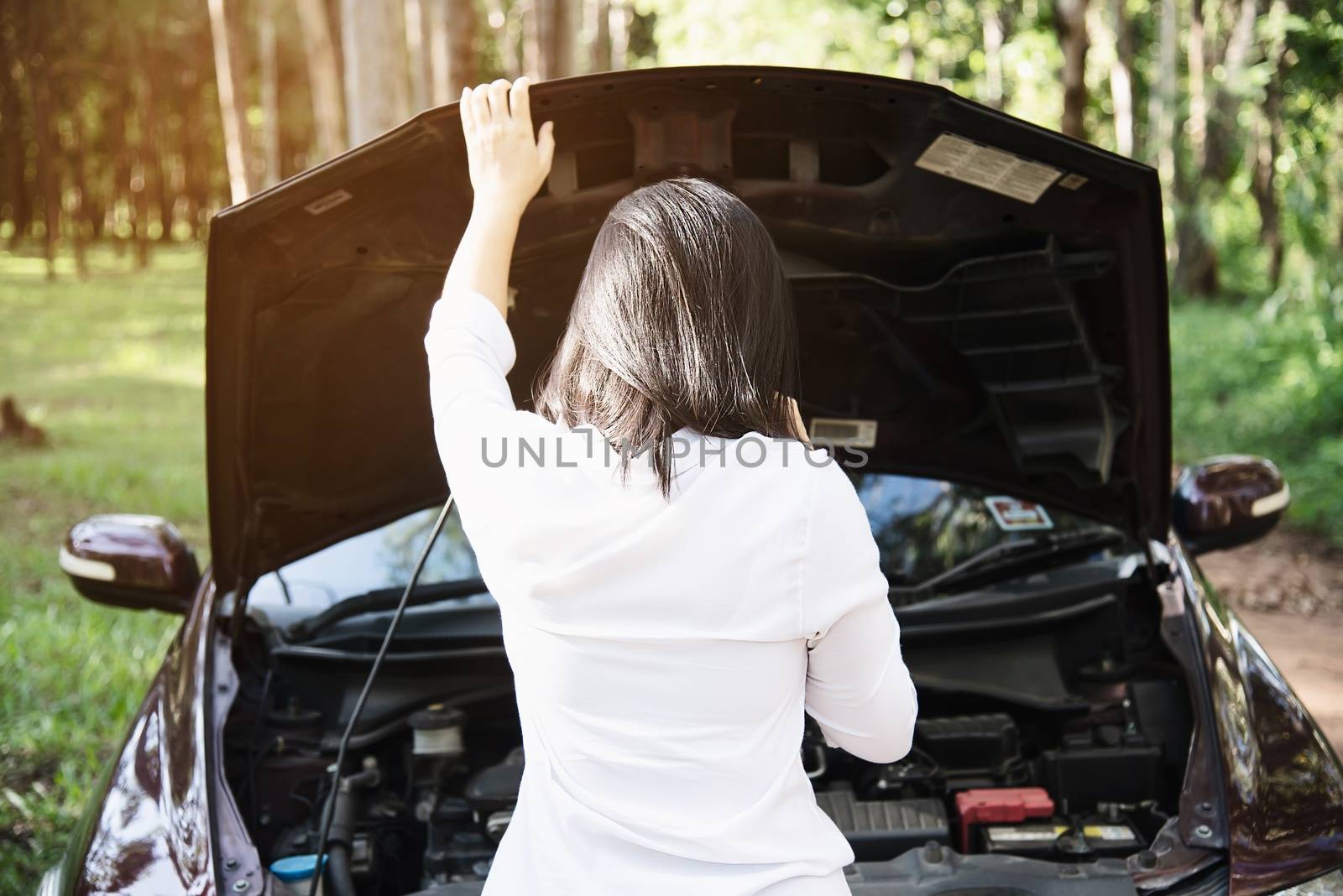 Asian woman calling repairman or insurance staff to fix a car engine problem on a local road - people with car problem transportation concept