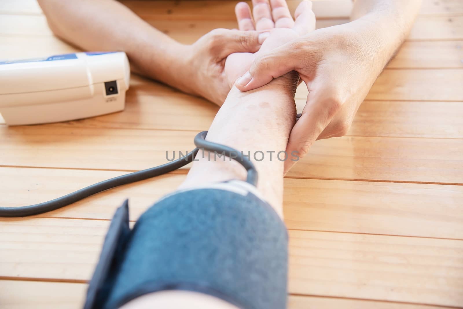 Old lady is being checked blood pressure using blood pressure monitor kid set by pairhandmade