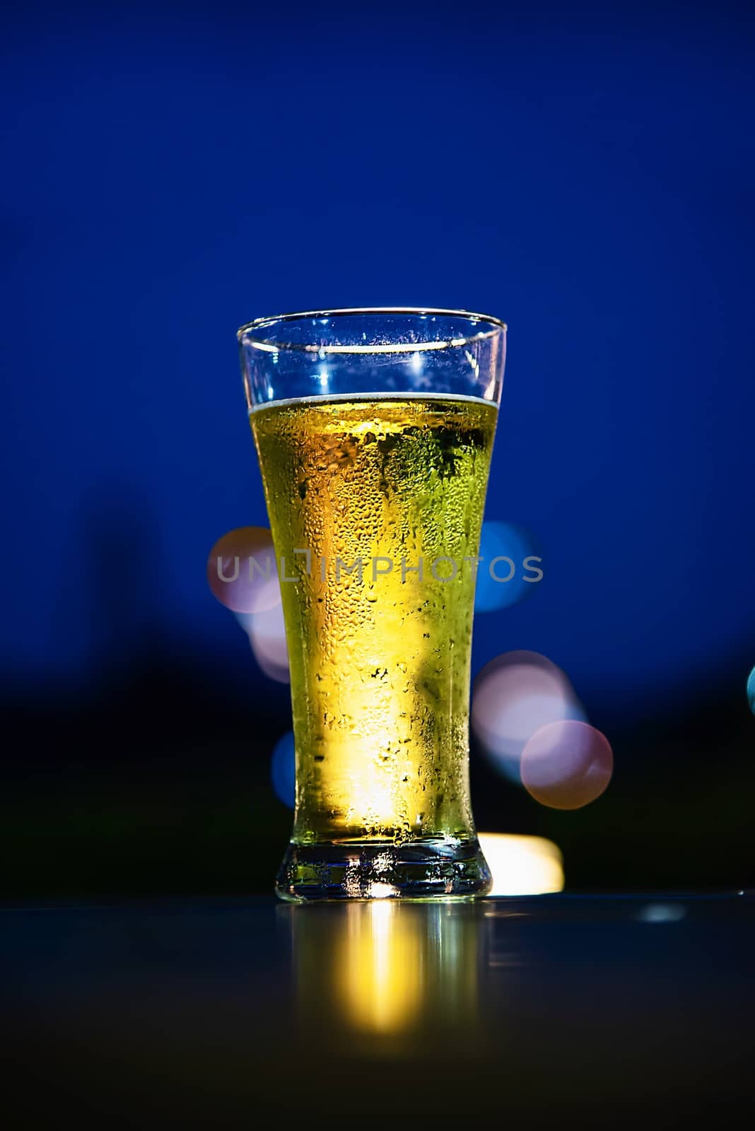 Cool beer glass in twilight - relax with beer in garden concept