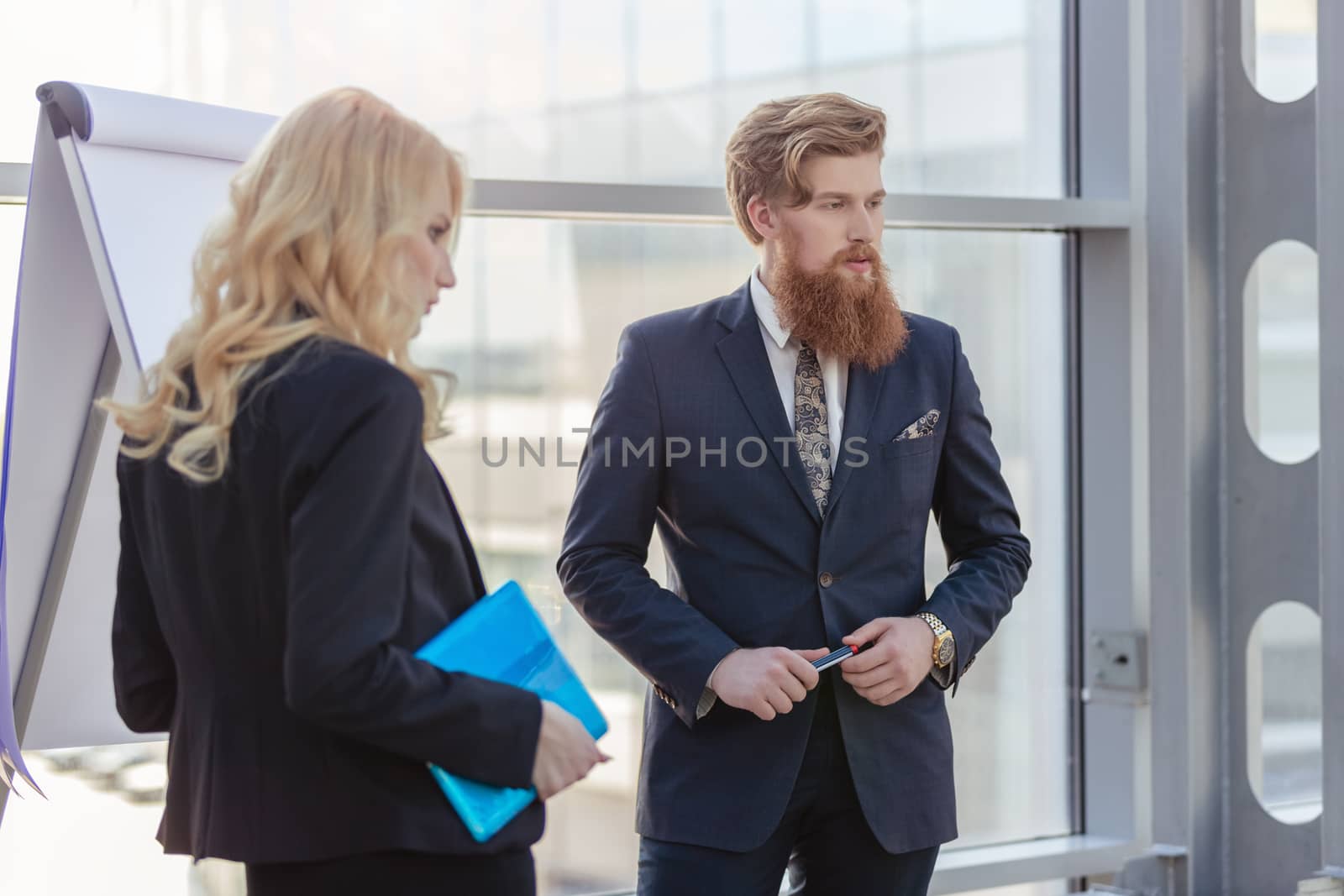 Two young business people giving flipchart presentation