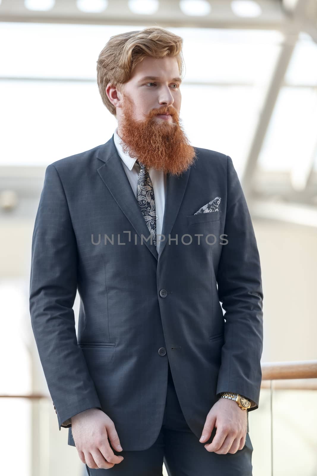 People, business, job, style, fashion and men's wear concept. good looking young Caucasian bearded male office worker wearing elegant suit in office