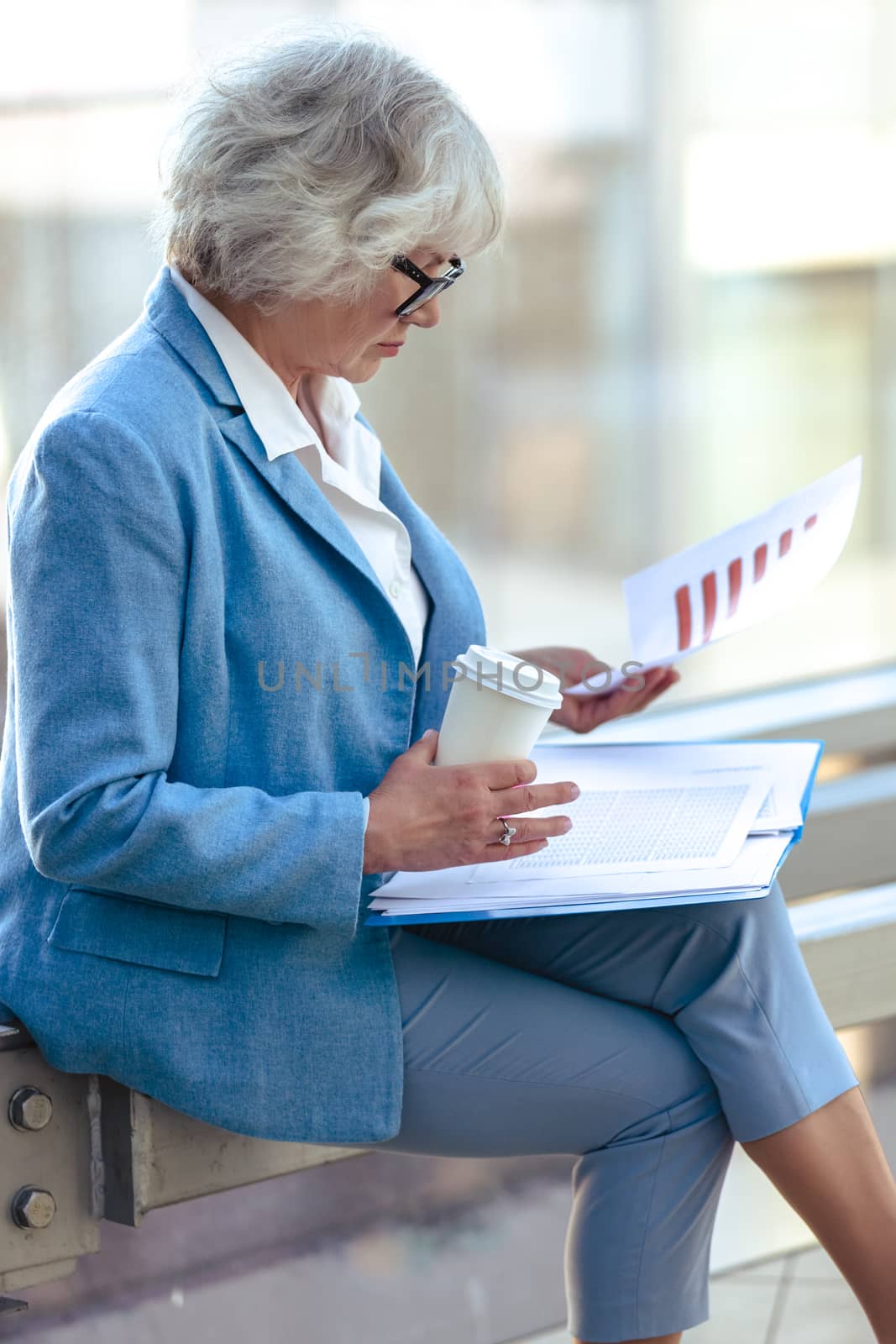 Senior business woman at coffee break with documents