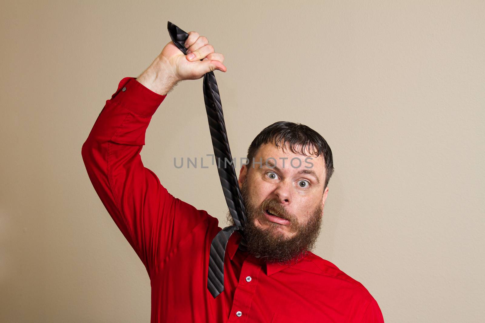 upset man at work trying to hang himself with a tie