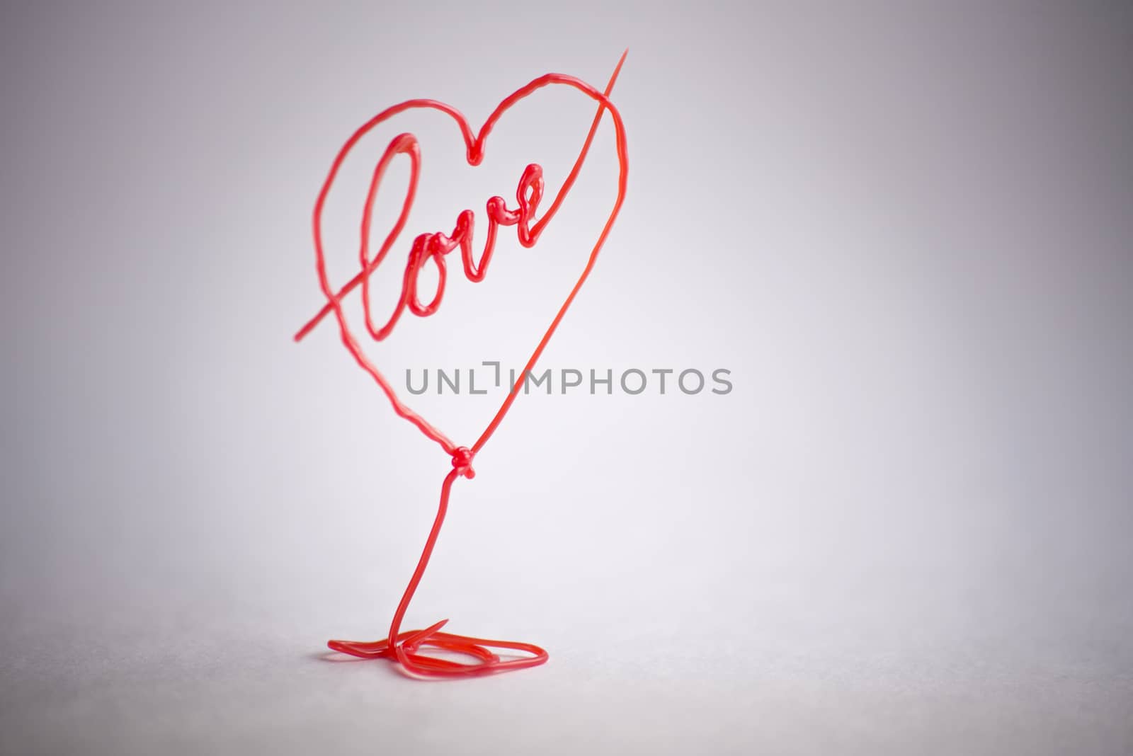 red heart drawn by 3d pen on white background