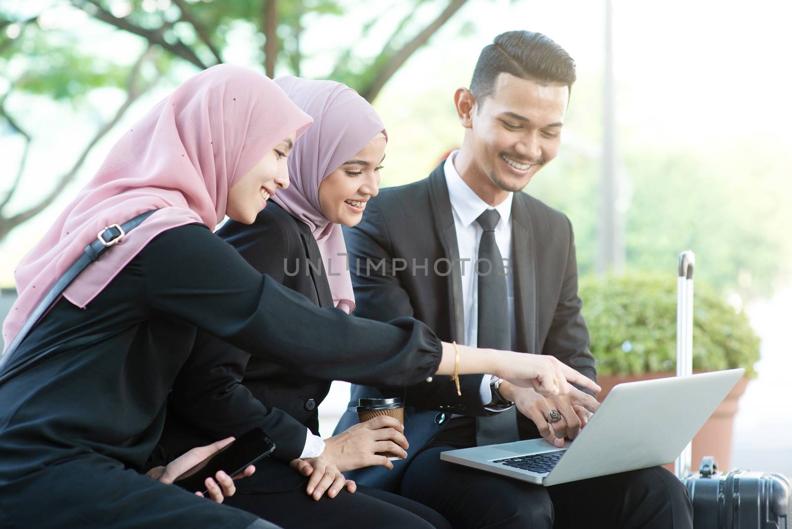 Muslim business people discussion with laptop, outdoor. 