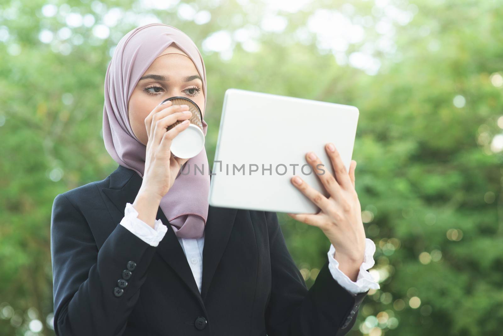 Muslim business woman drinking coffee while going to work in morning.