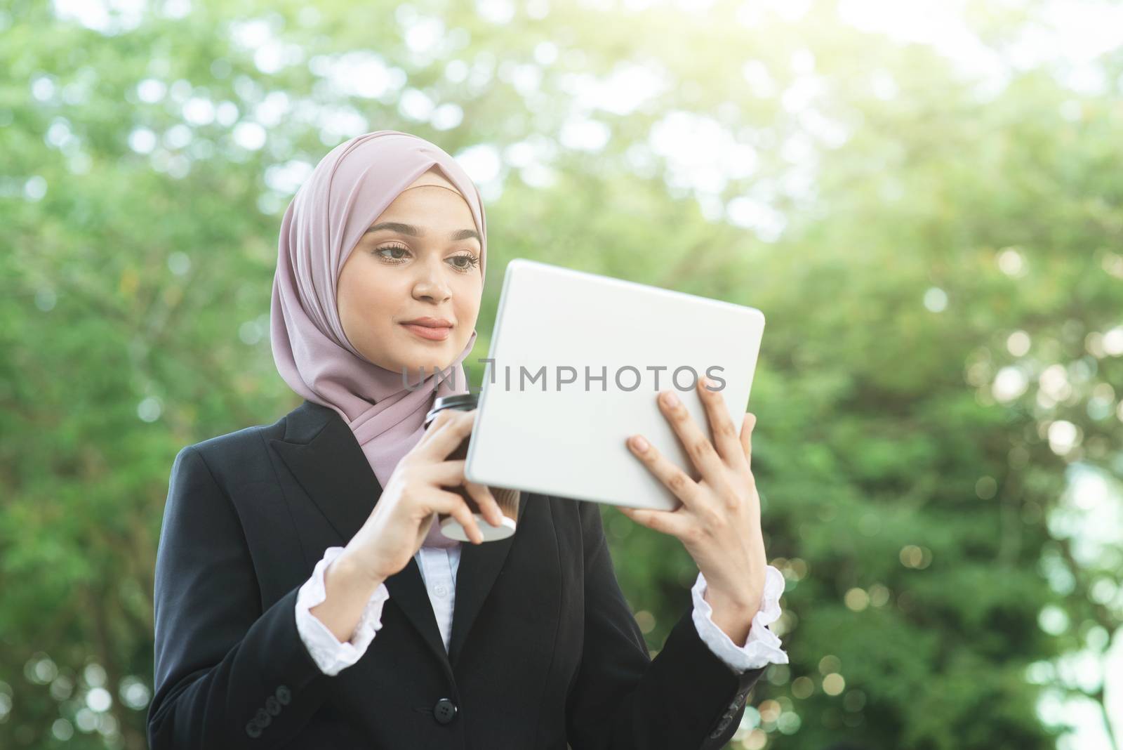 Muslim business woman drinking coffee while going to work in morning.