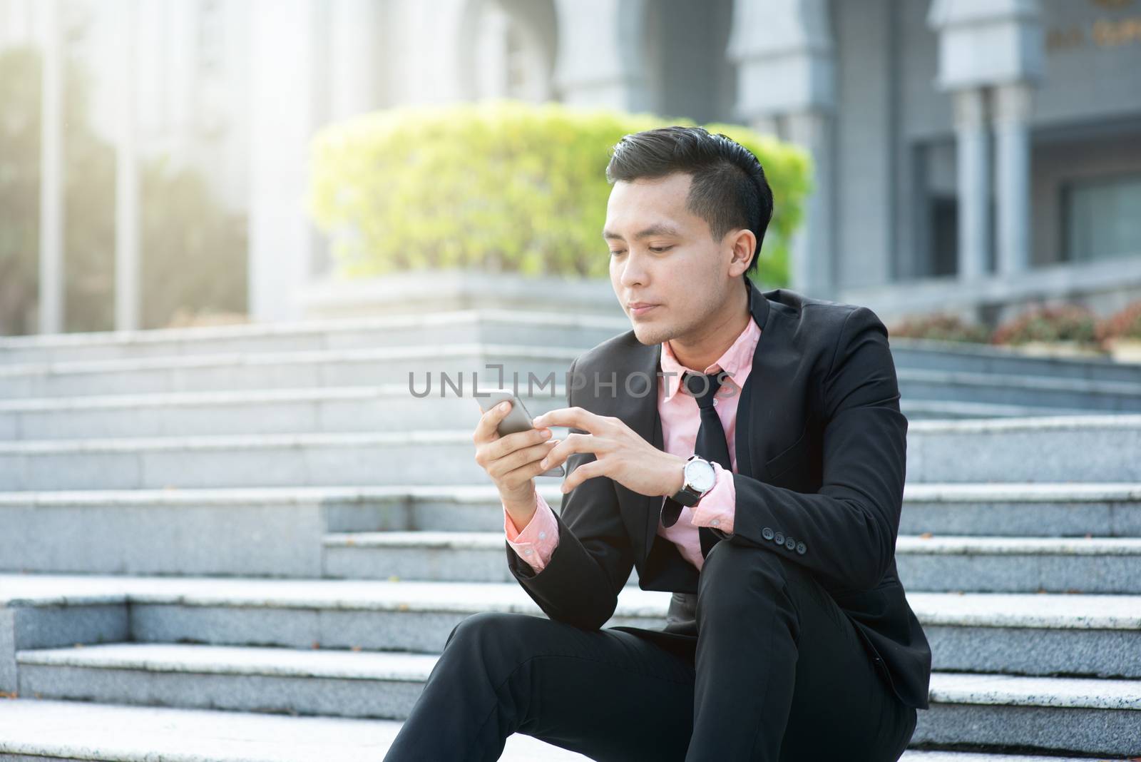 Man looking at mobile phone with serious face, negative emotion, phishing scams concept.