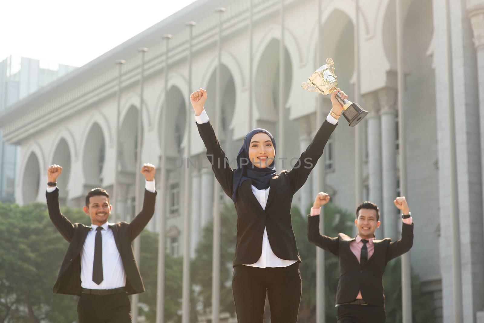 Muslim businesswoman holding a trophy, woman power in business, top performance concept.