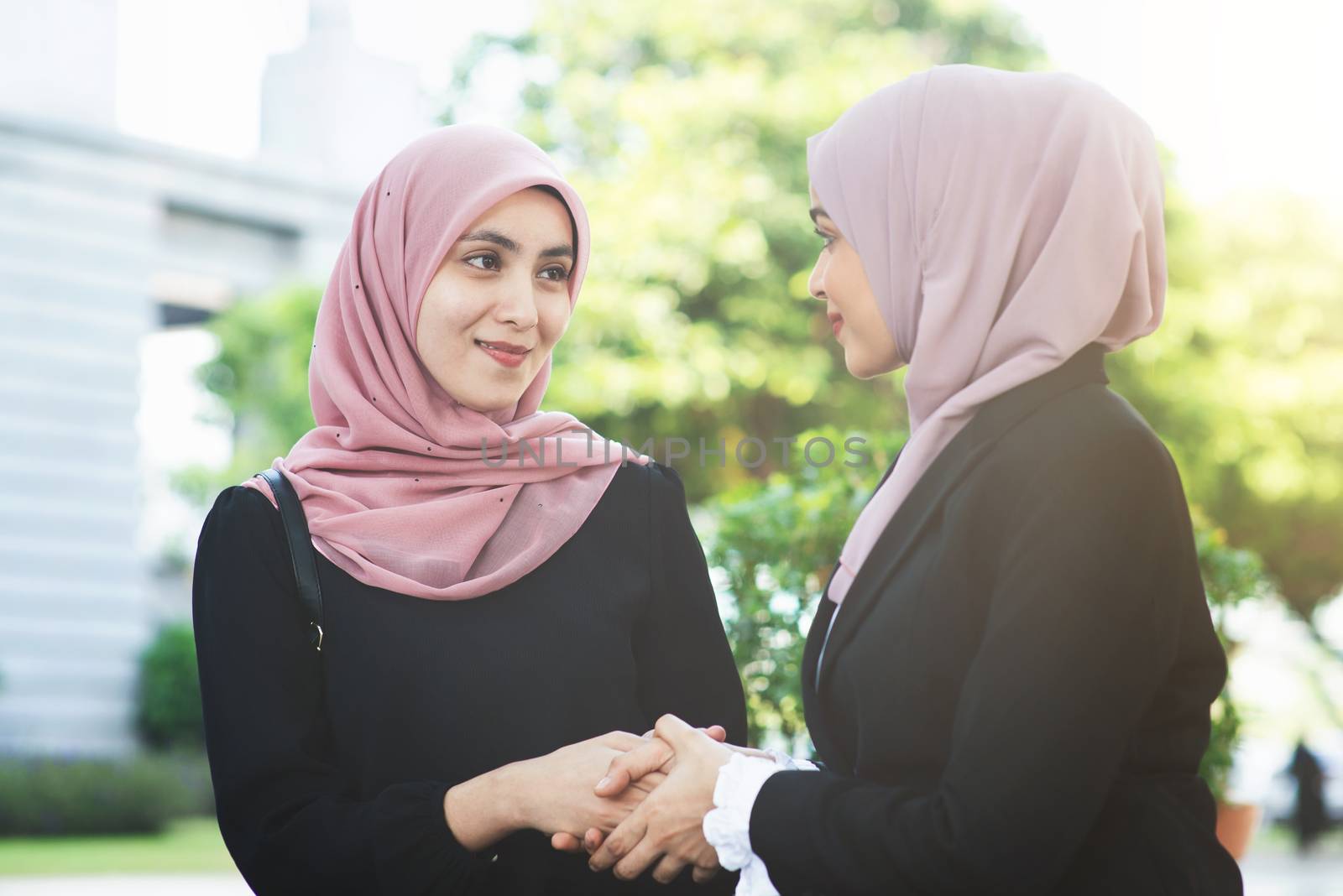 Muslim business women greeting, handshake and smiling.