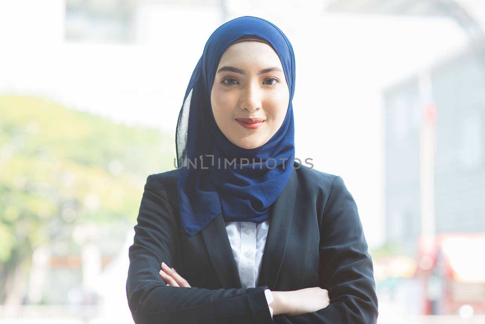 Portrait of Muslim woman in business suit, arms crossed and smile looking at camera.