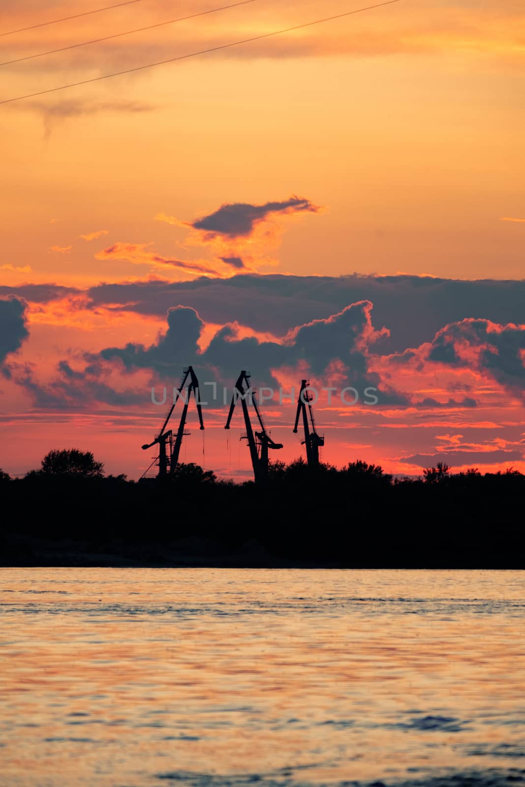 Sunset on the embankment of the Amur river in Khabarovsk. The sun set over the horizon. The embankment is lit by lanterns.