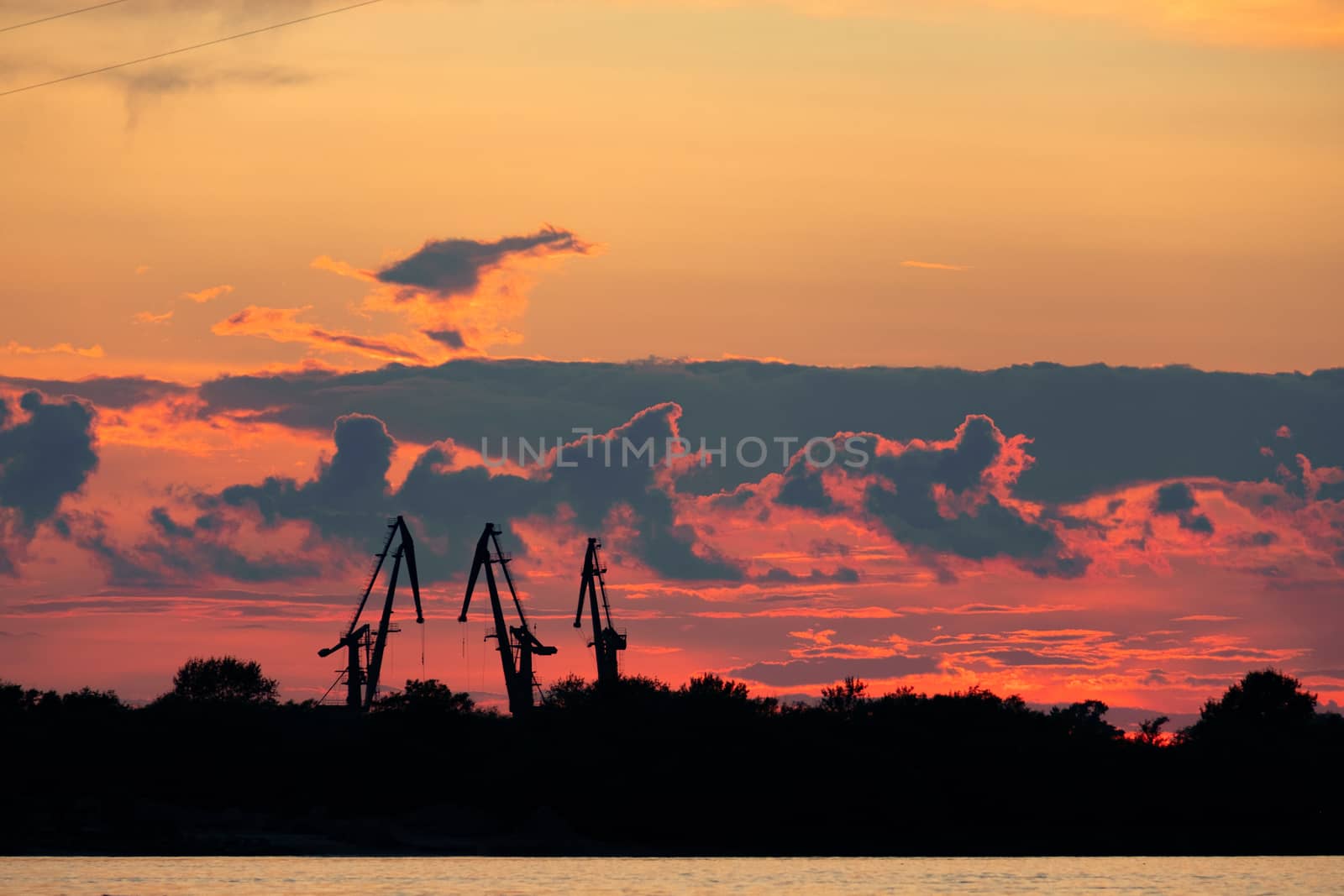 Sunset on the embankment of the Amur river in Khabarovsk. The sun set over the horizon. The embankment is lit by lanterns.