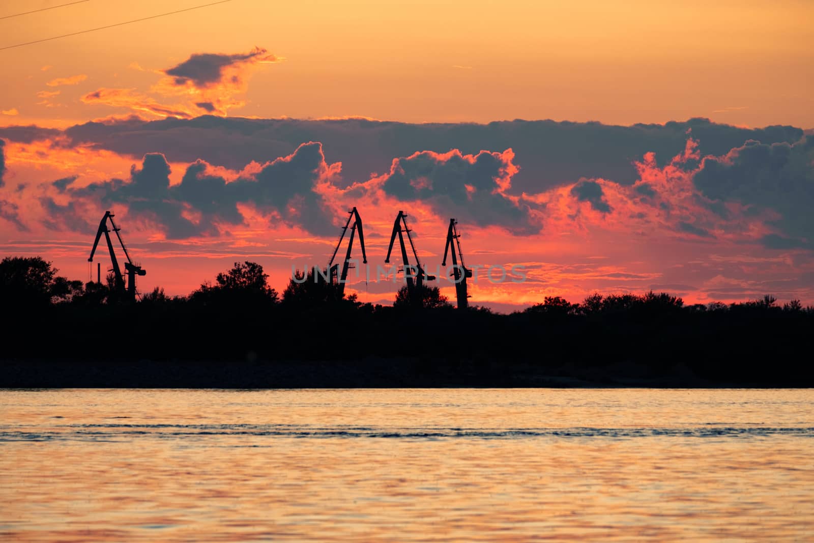 Sunset on the embankment of the Amur river in Khabarovsk. The sun set over the horizon. The embankment is lit by lanterns.