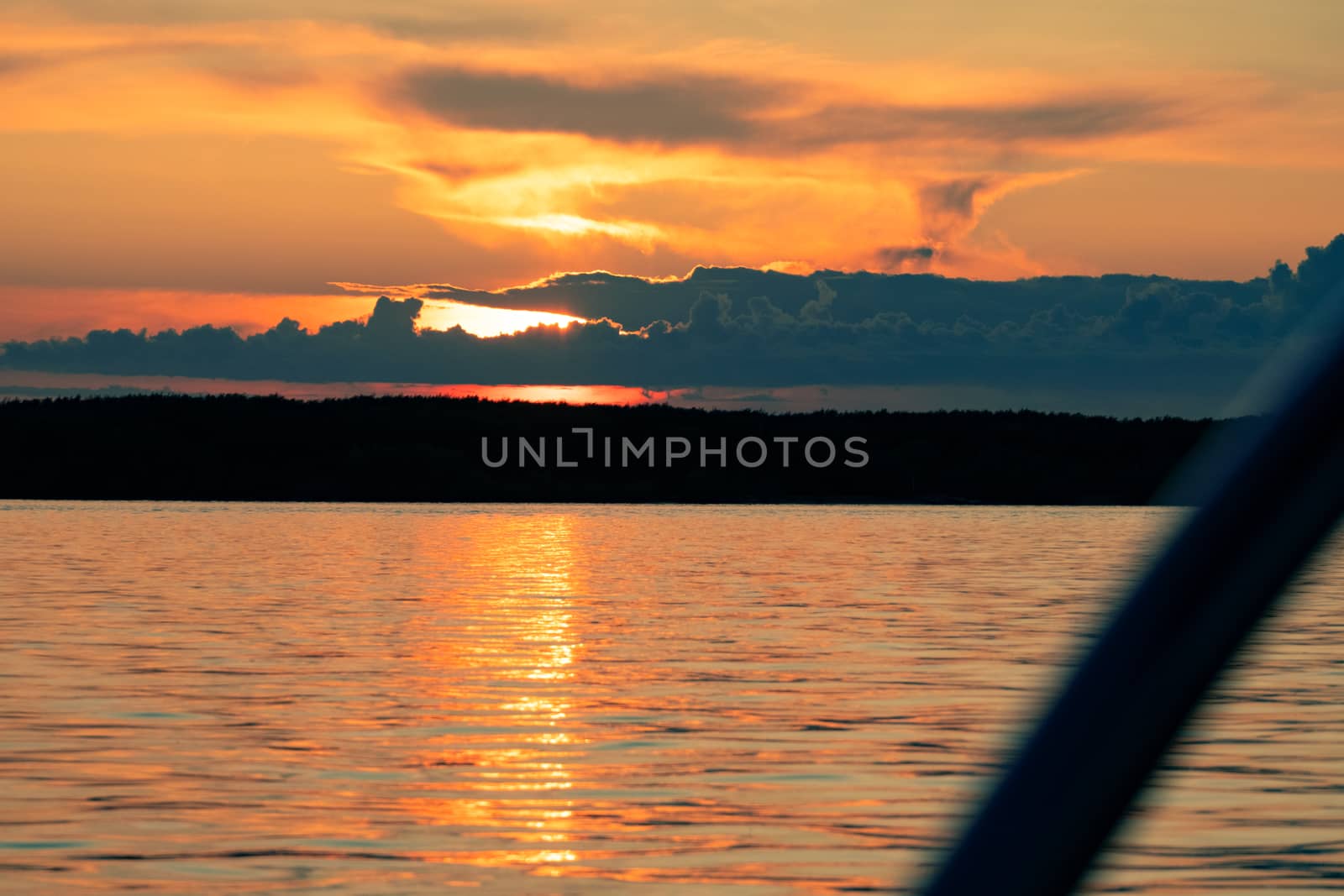 Sunset on the embankment of the Amur river in Khabarovsk. The sun set over the horizon. The embankment is lit by lanterns.