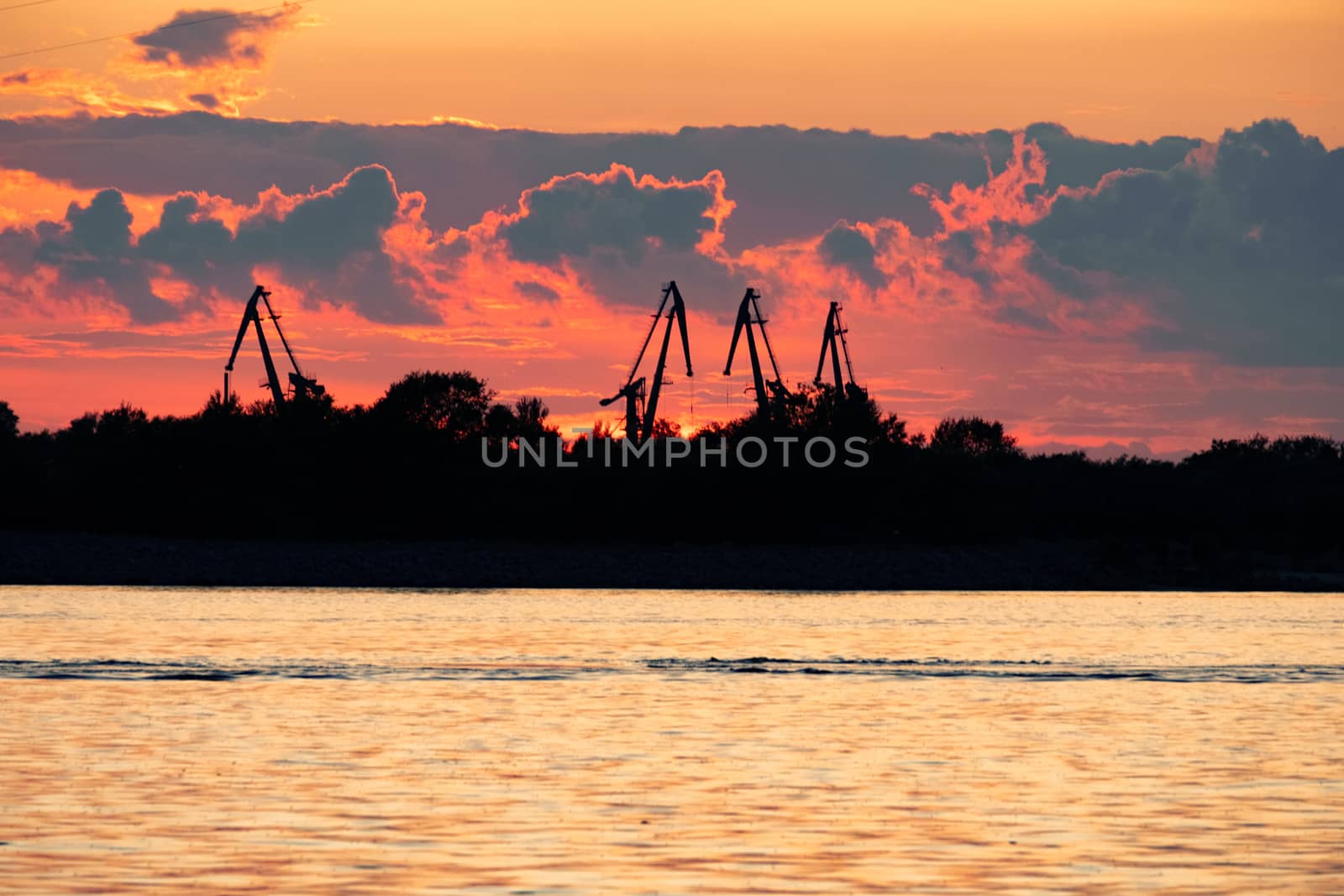 Sunset on the embankment of the Amur river in Khabarovsk. The sun set over the horizon. The embankment is lit by lanterns.