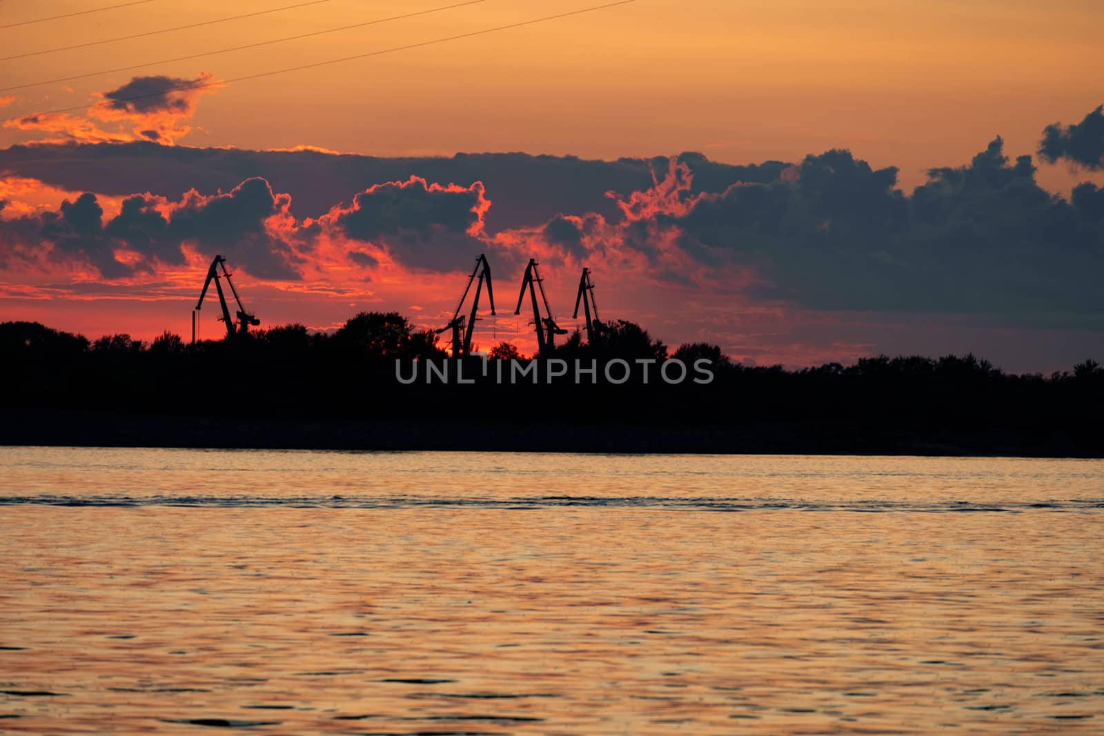 Sunset on the embankment of the Amur river in Khabarovsk. The sun set over the horizon. The embankment is lit by lanterns.