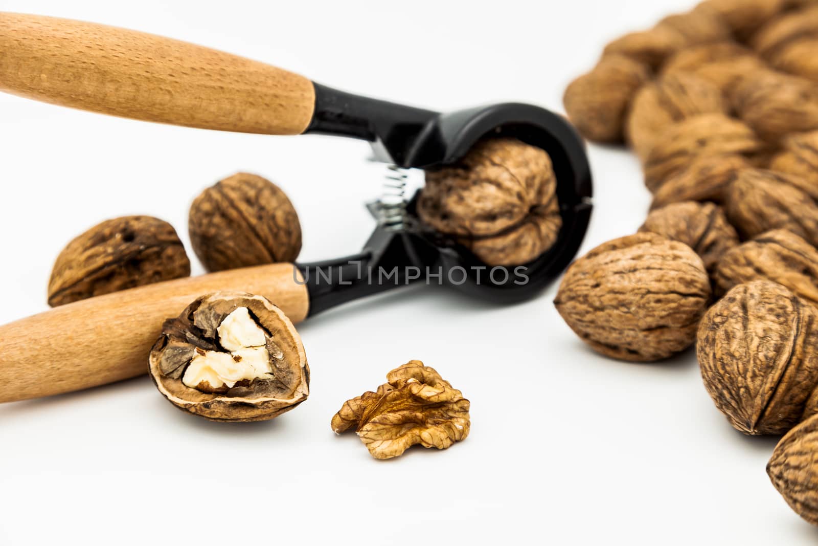 A composition of walnuts, cracked walnuts and a nutcraker