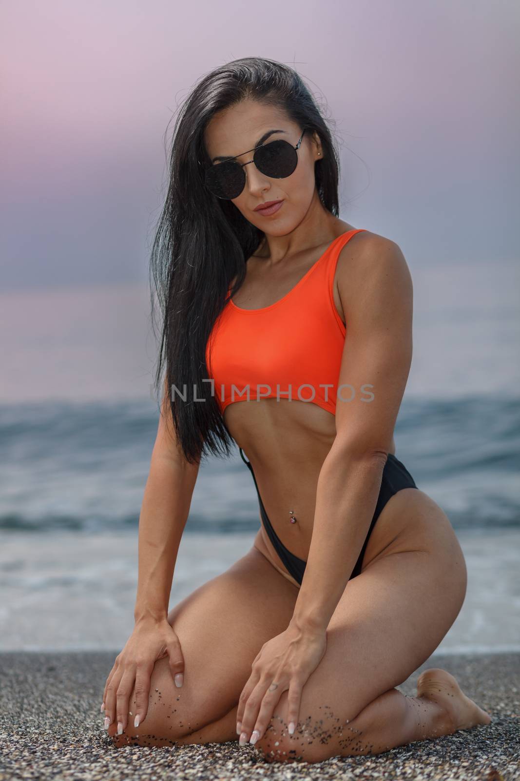 Fitness girl posing with a beautiful black and orange bikini by viledevil