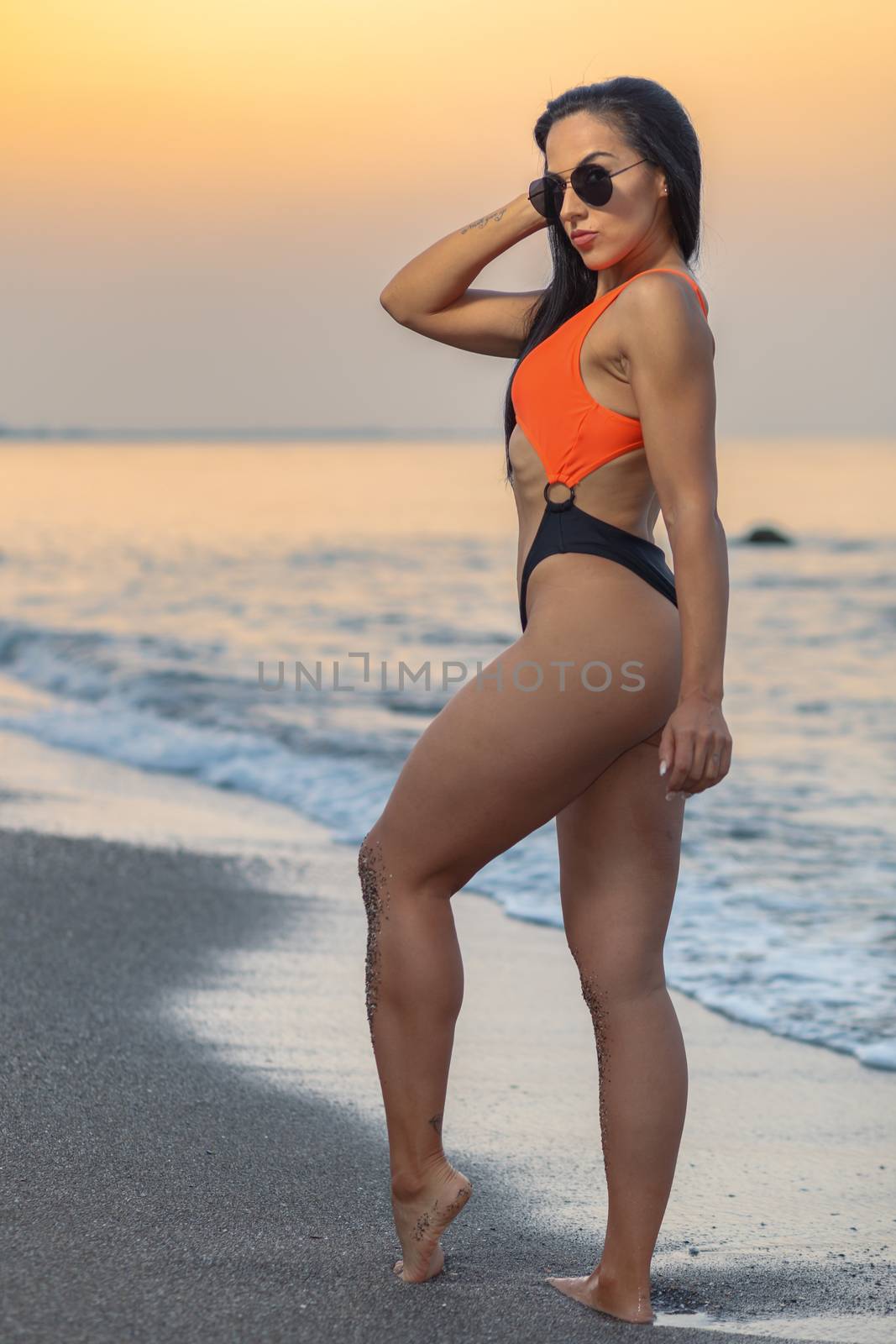 Fitness girl posing with a beautiful black and orange bikini by viledevil