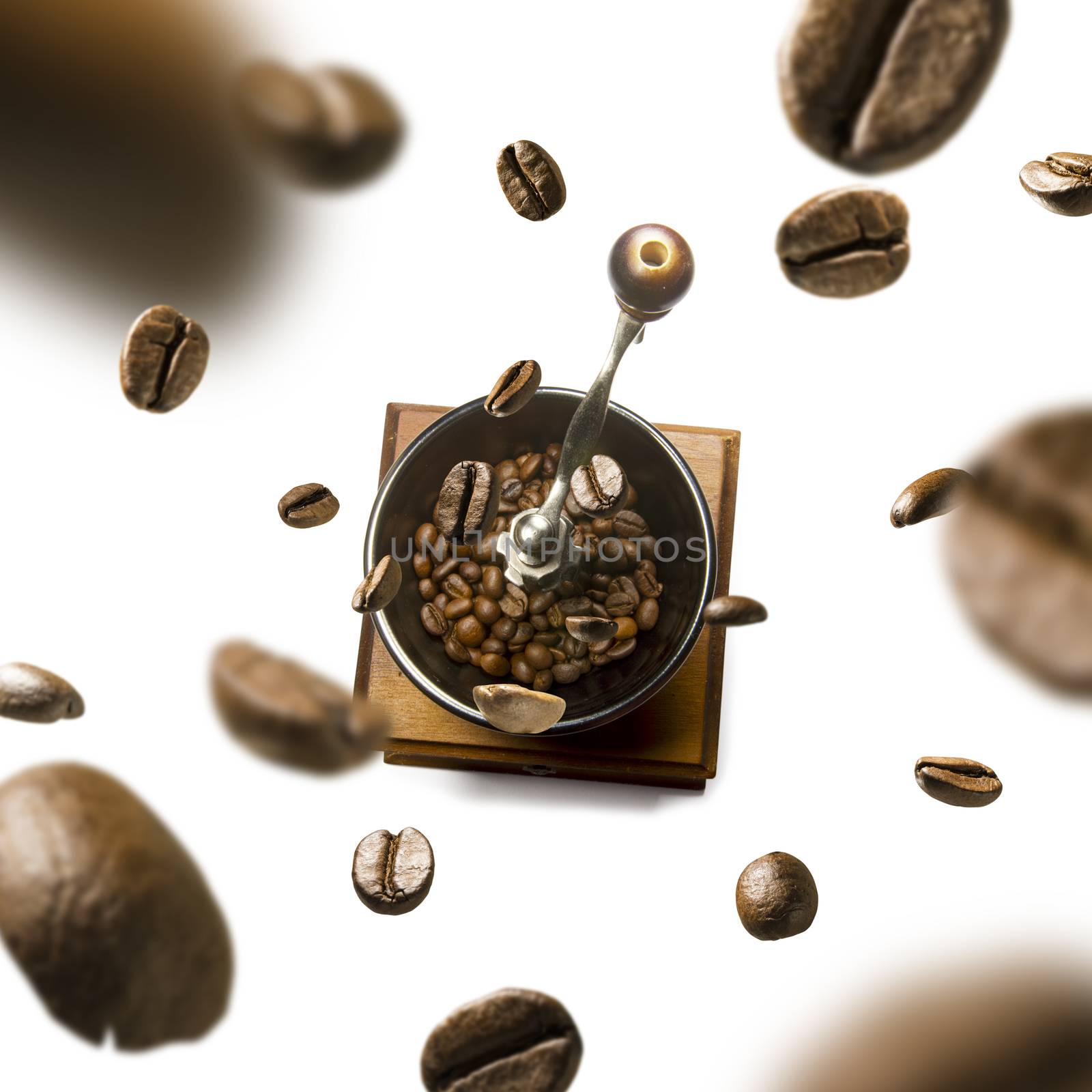 Coffee grinder and coffee beans in flight on white background.