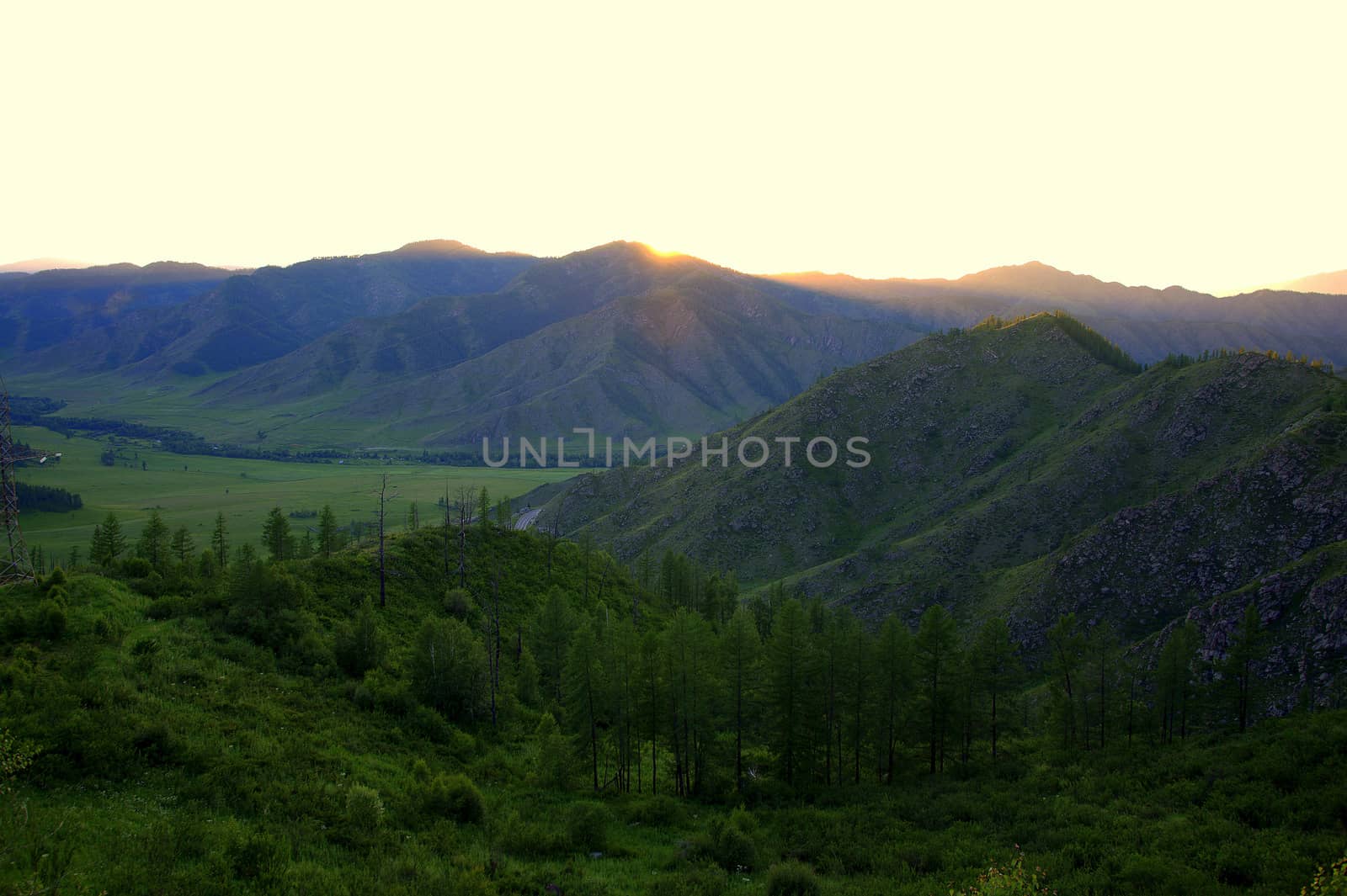 Sunset in a mountain valley, the last rays of the sun touched the peaks. Altai, Siberia, Russia.