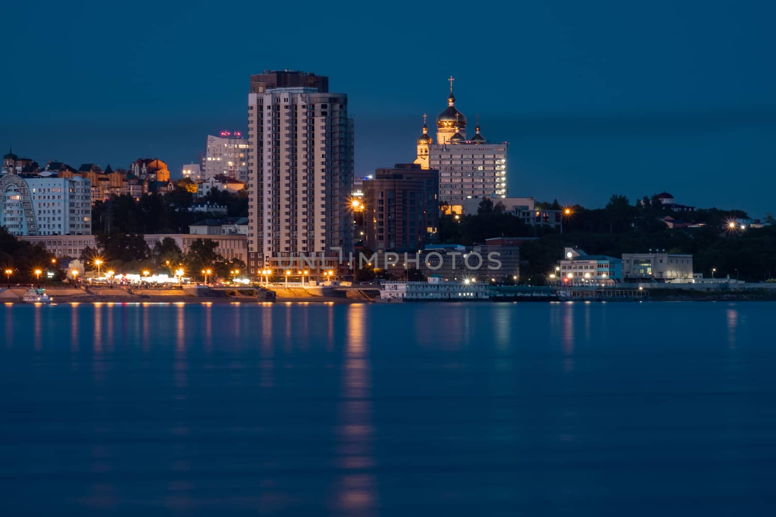 Night View of the city of Khabarovsk from the Amur river. Blue night sky. The night city is brightly lit with lanterns. The level of the Amur river at around 159 centimeters. by rdv27