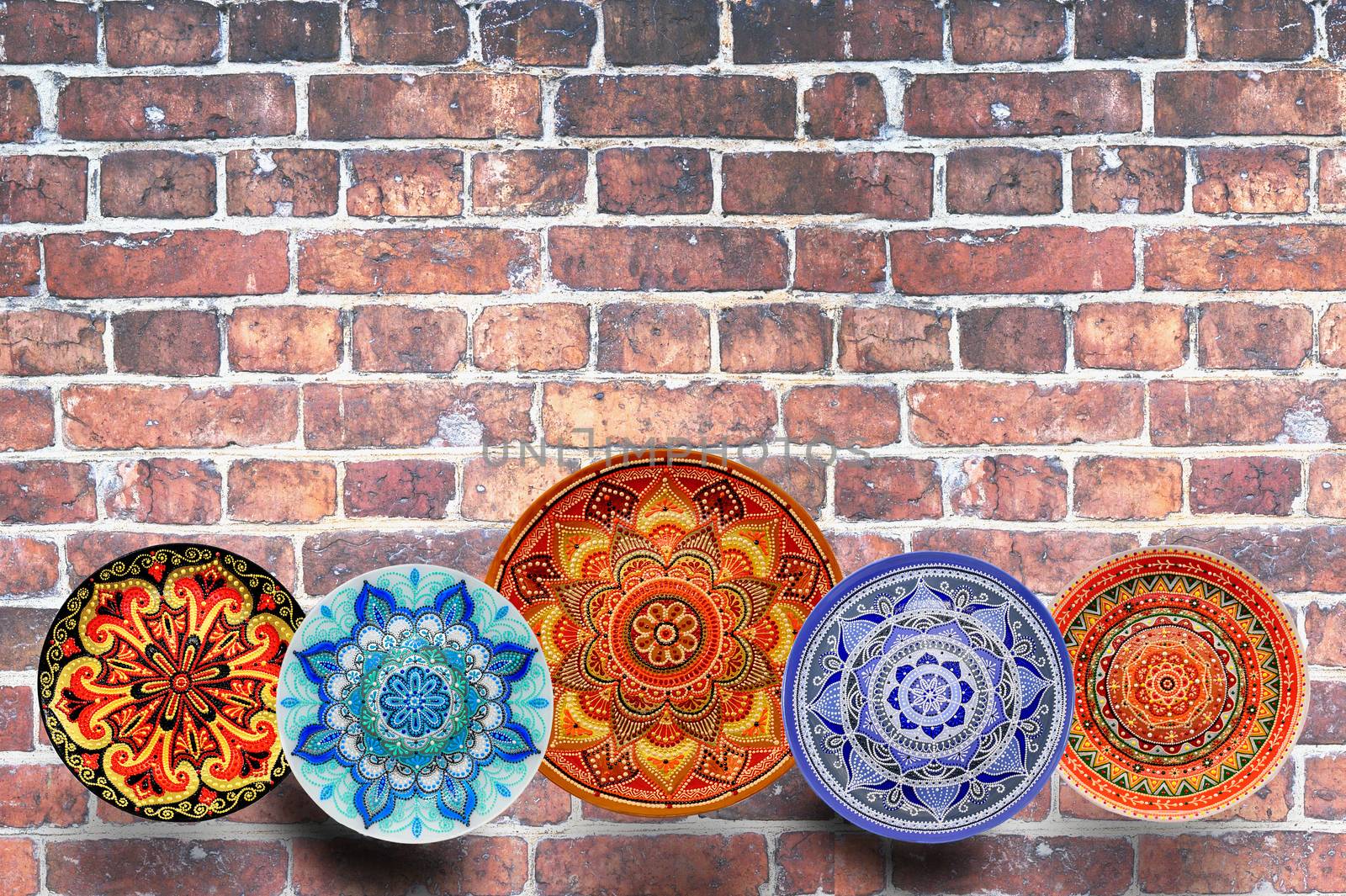 Set of decorative ceramic plates hand-painted with acrylic paints on a brick background with place for text