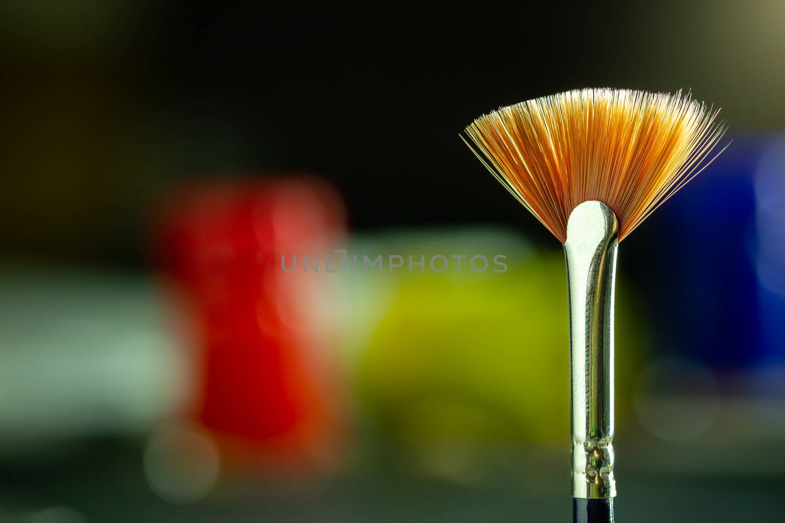 Closeup artist paint brush and poster color bottle blur backgrou by SaitanSainam