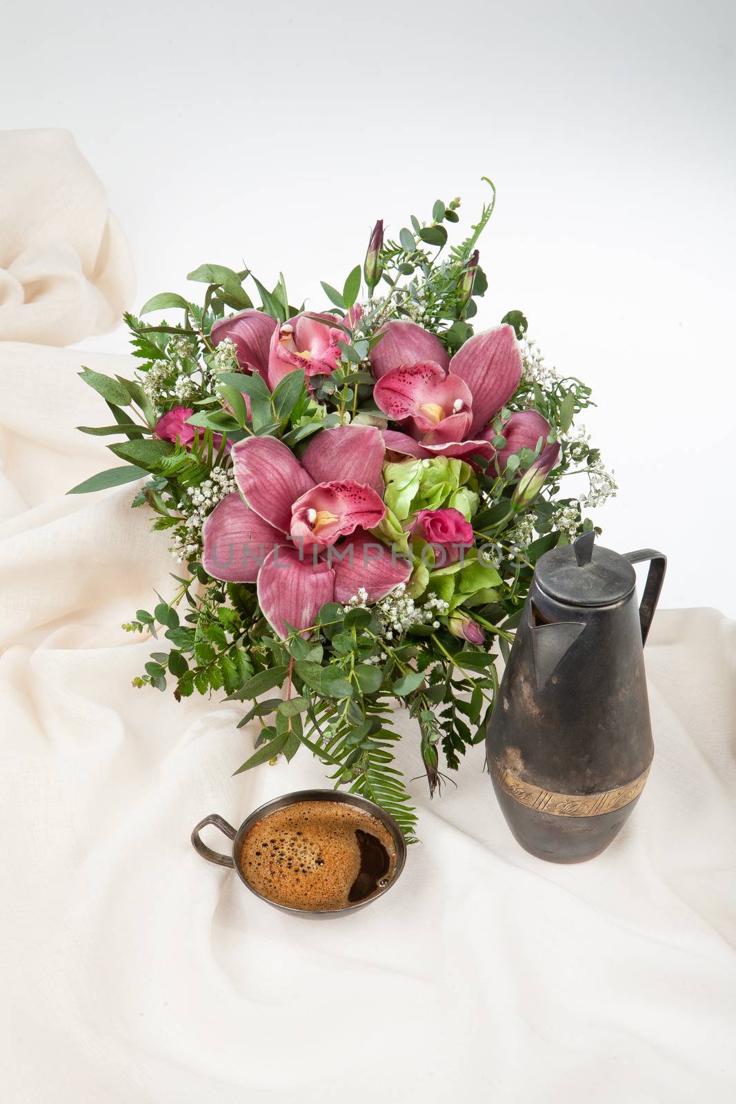 Cup of coffee and coffee pot on a fabric background