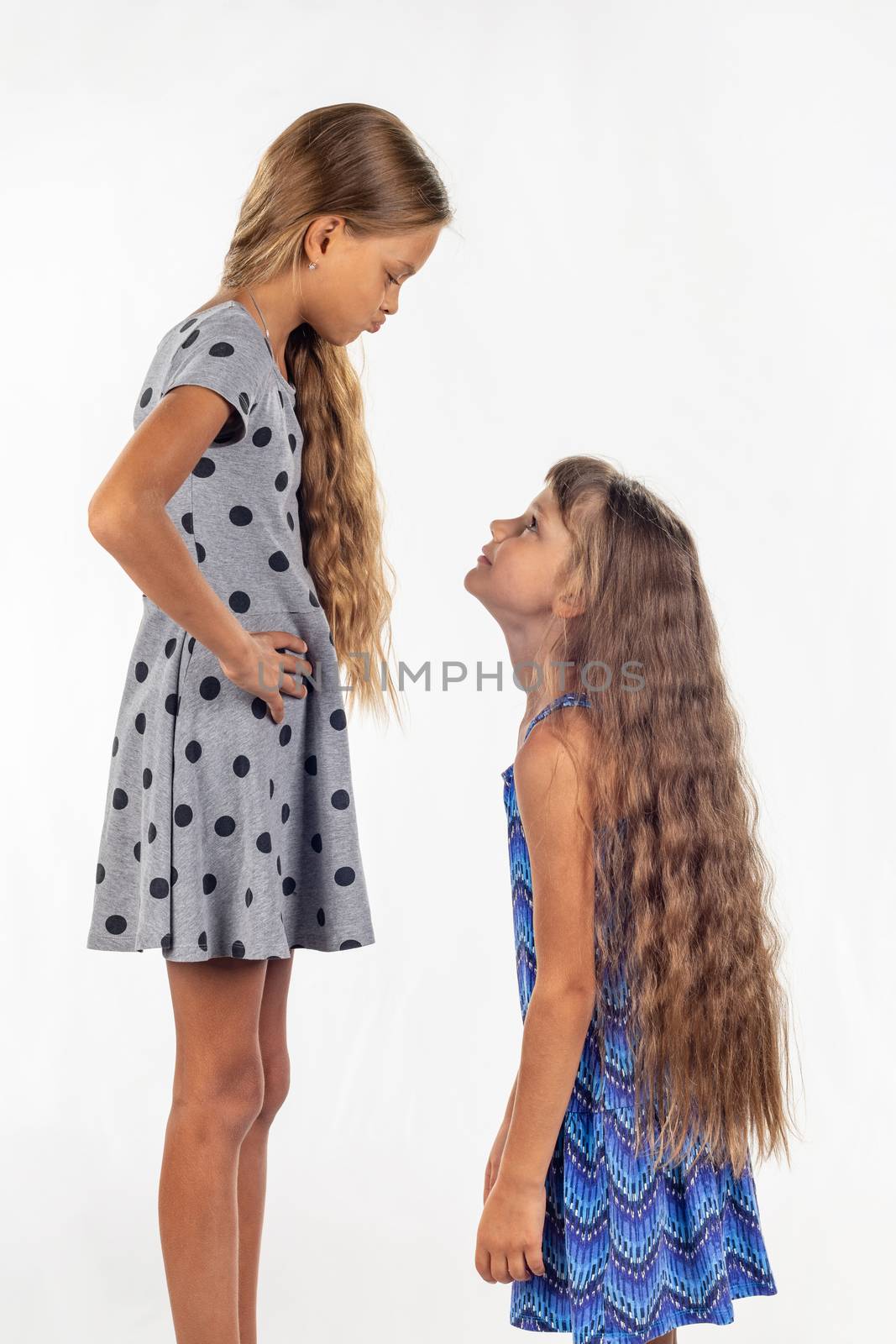 Two girls of different stature, one stood on a chair and became even taller