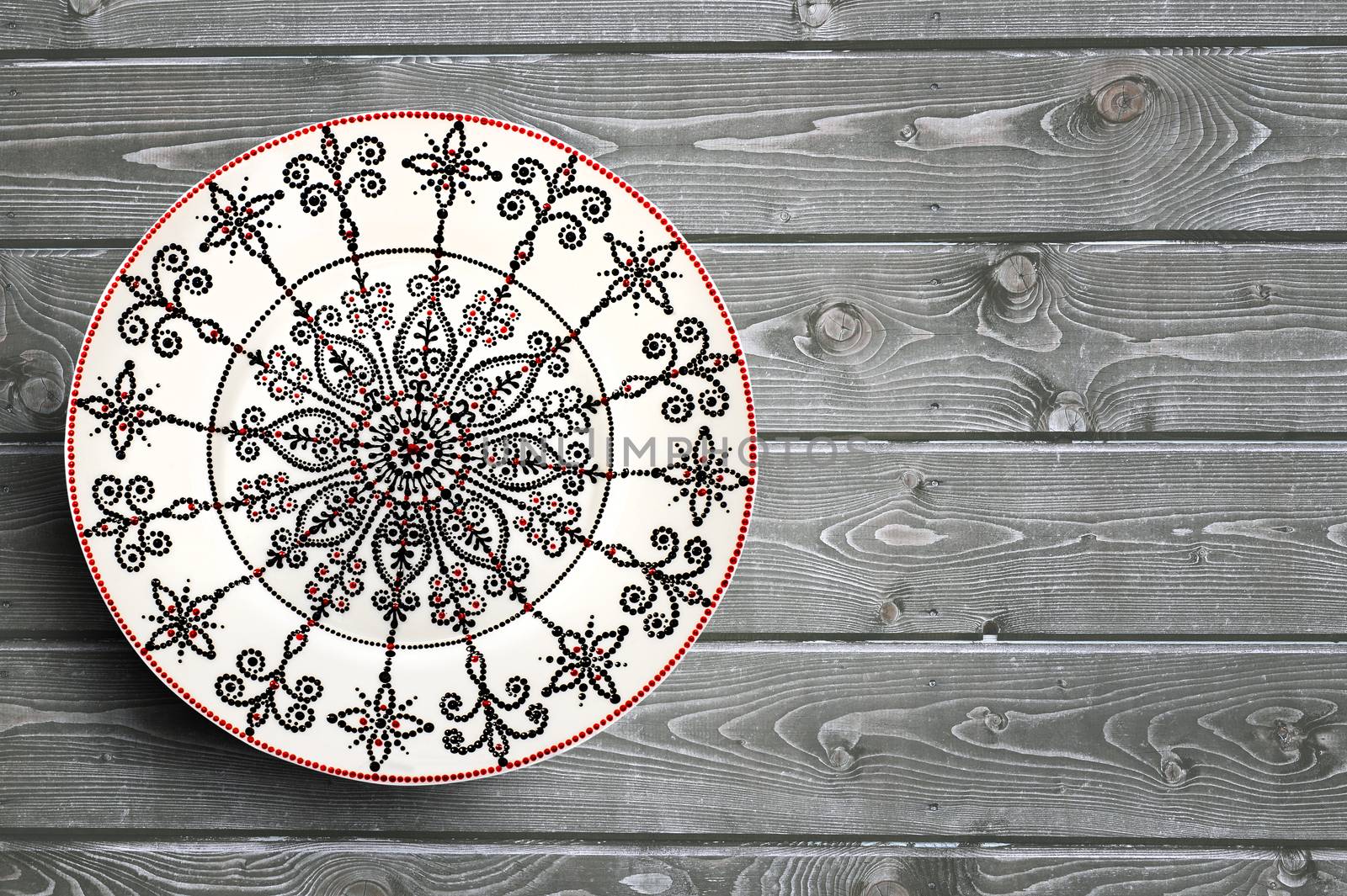 Set of decorative ceramic plates hand painted dot pattern with acrylic paints on a gray wooden background. Copy space