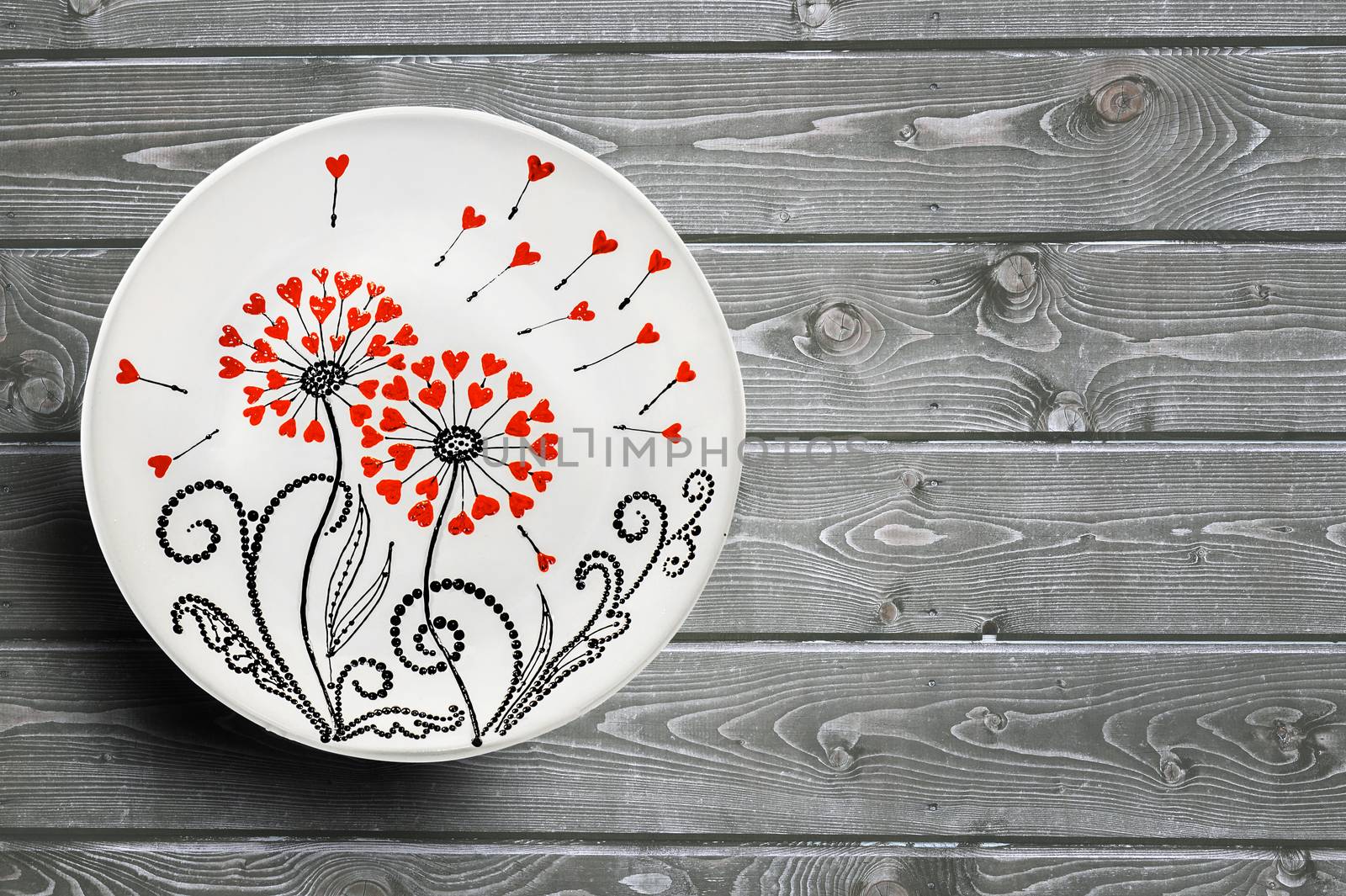 Set of decorative ceramic plates hand painted dot pattern with acrylic paints on a gray wooden background. Copy space