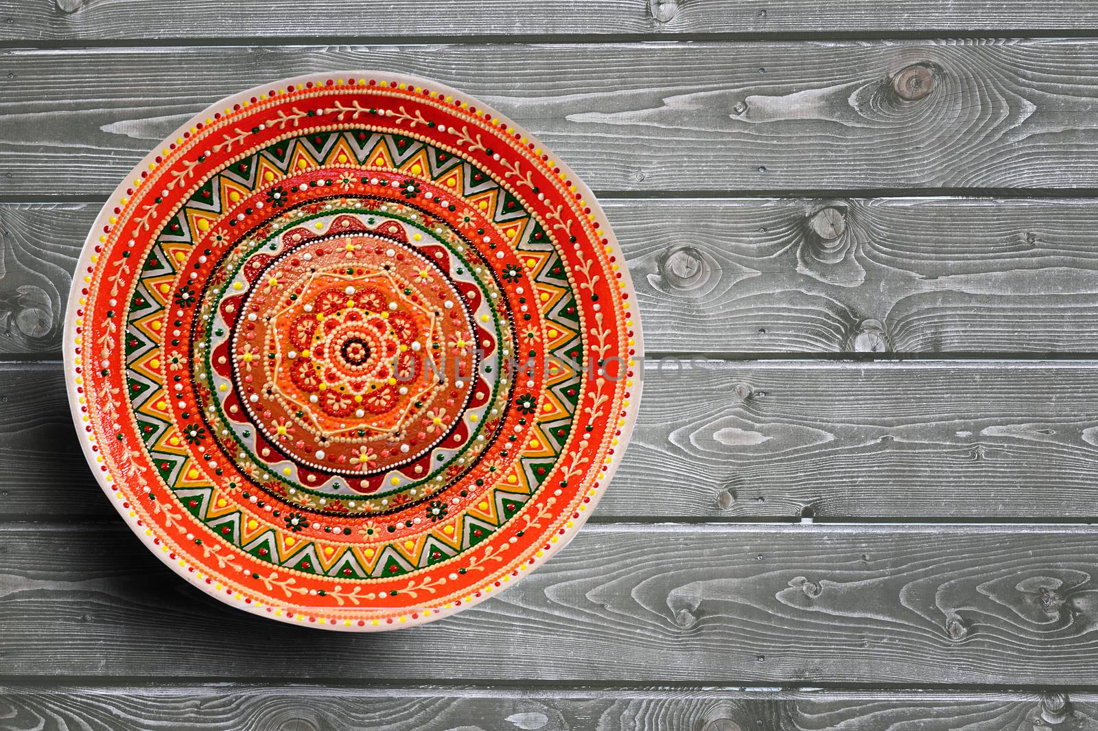 Set of decorative ceramic plates hand painted dot pattern with acrylic paints on a gray wooden background. Copy space