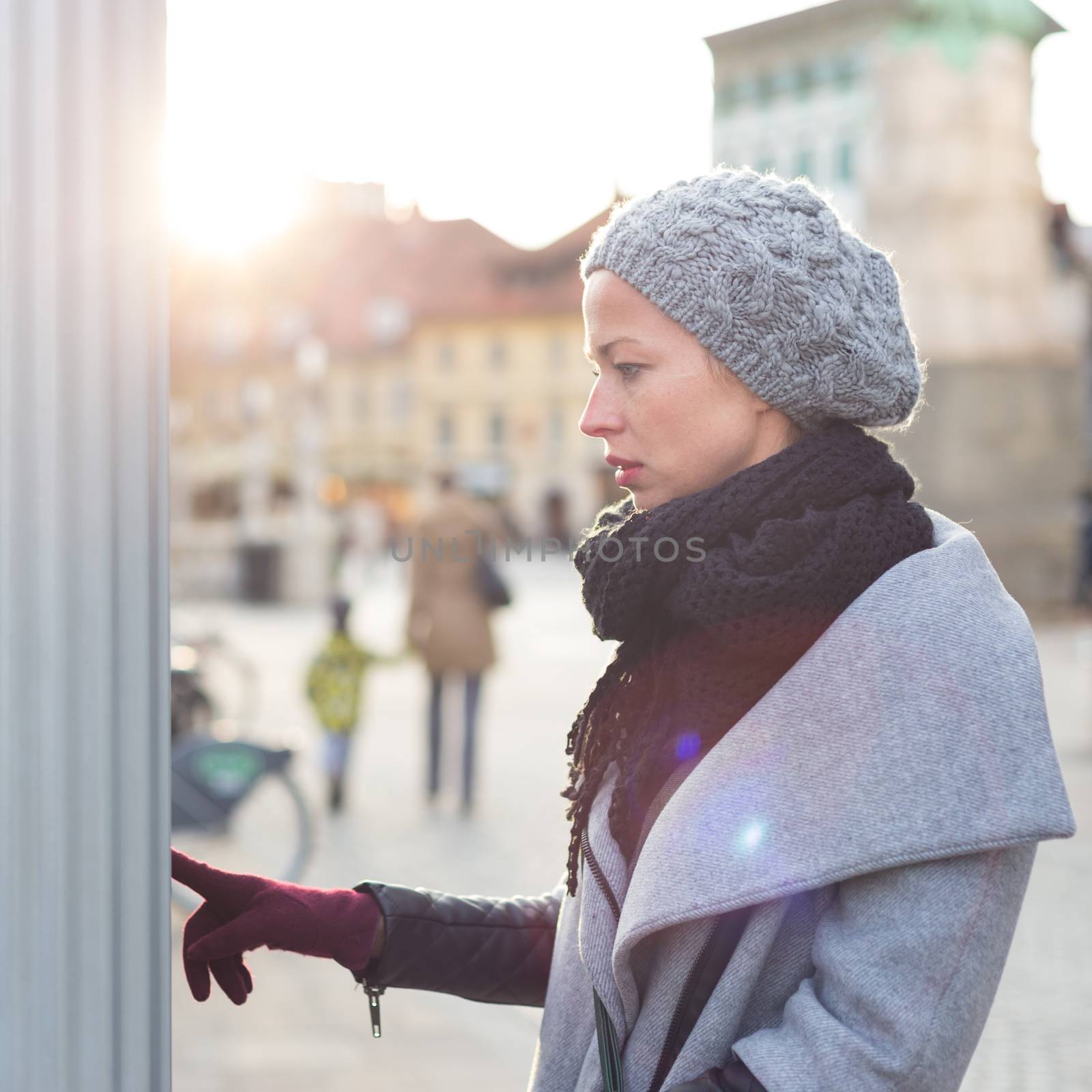 Casual woman buying public transport tickets on city urban vedning machine on cold winter day. by kasto