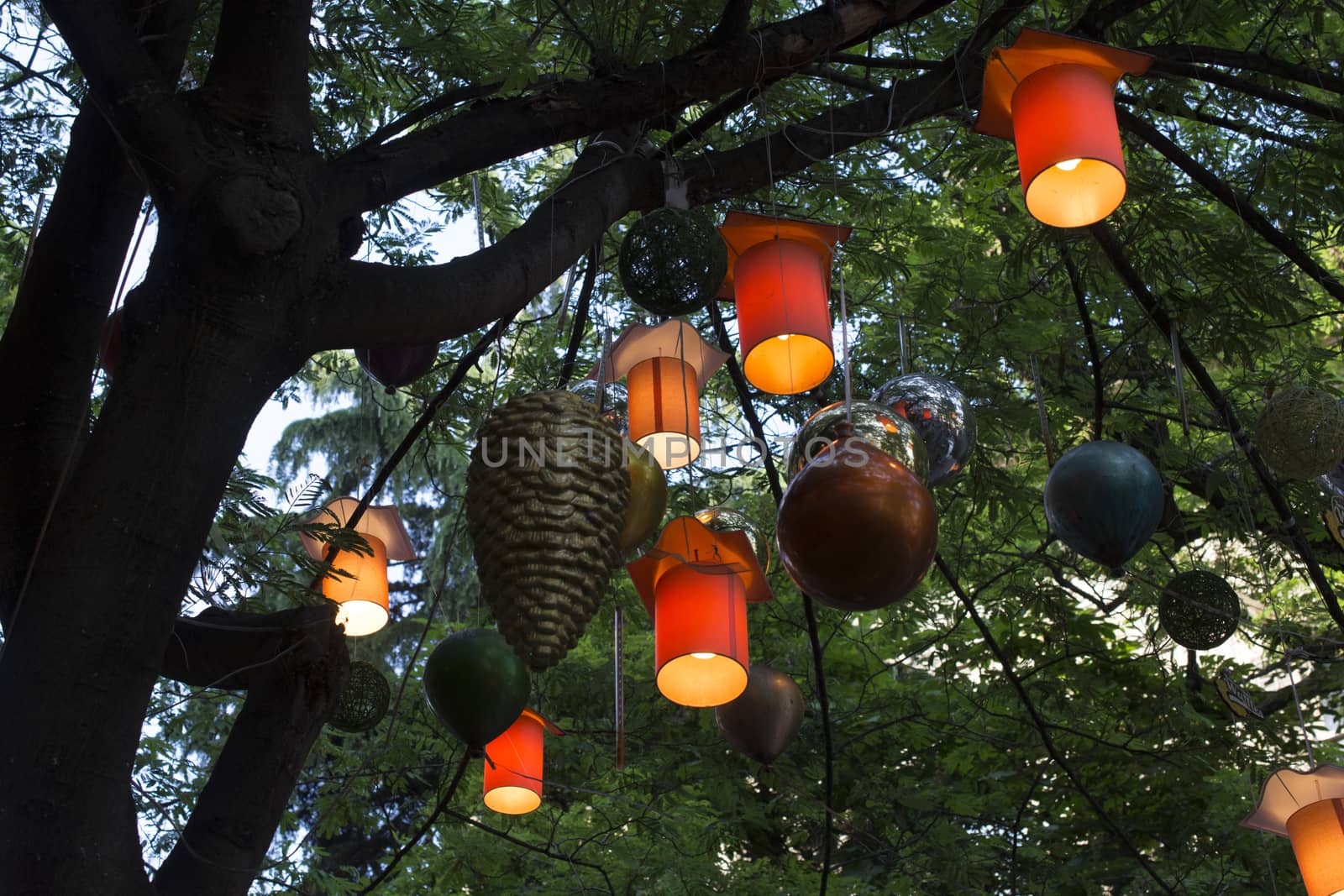 Adorned street trees. There are decorative balls, balloons, lamps and oil lamp