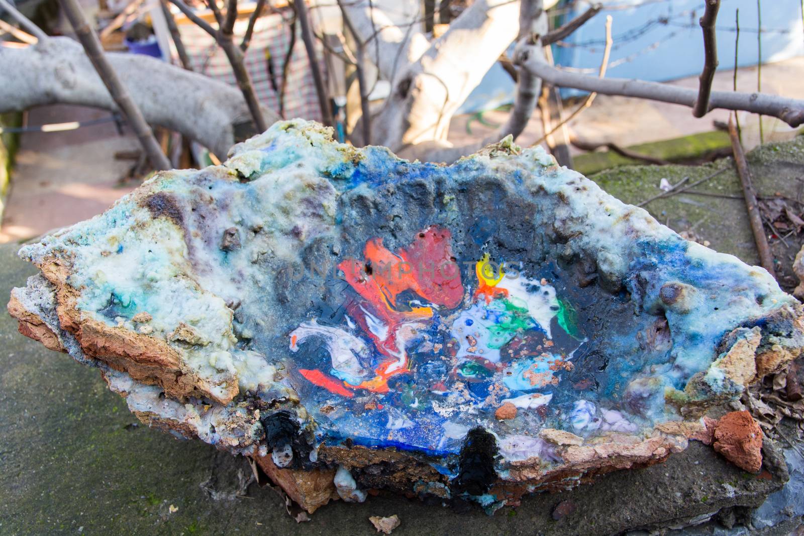 oven melting furnace used in making evil eye beads. over time the remaining residues from the beads stick to the oven pan. a colored mold is formed