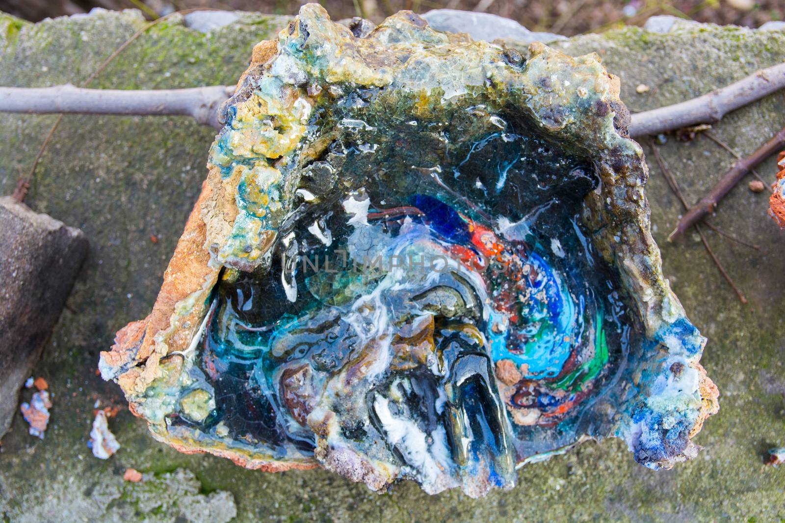 oven melting furnace used in making evil eye beads. over time the remaining residues from the beads stick to the oven pan. a colored mold is formed