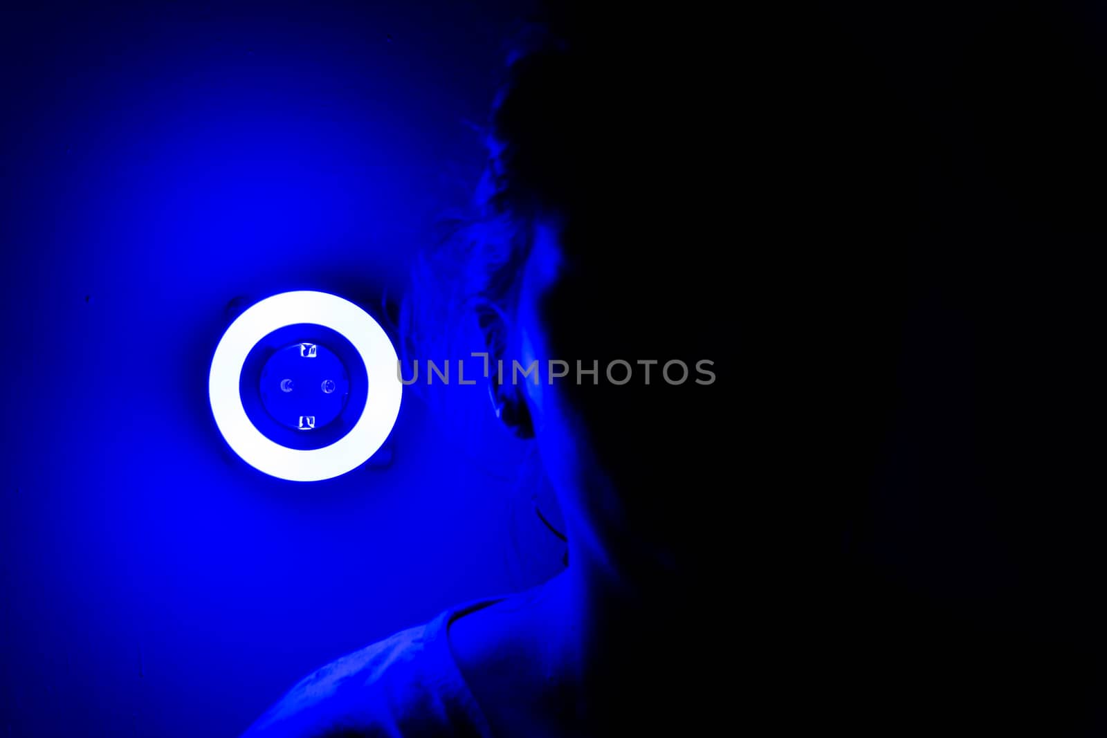 Lamp night light in a dark background. Vintage effect style picture. ring lamp. Neon light circle. the light takes the shape of a circle.the woman hiding in the dark. a symbol of violence for women