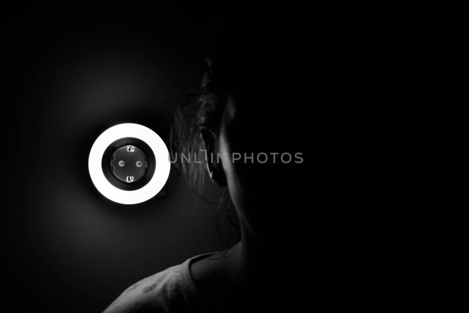 Lamp night light in a dark background. Vintage effect style picture. ring lamp. Neon light circle. the light takes the shape of a circle.the woman hiding in the dark. a symbol of violence for women