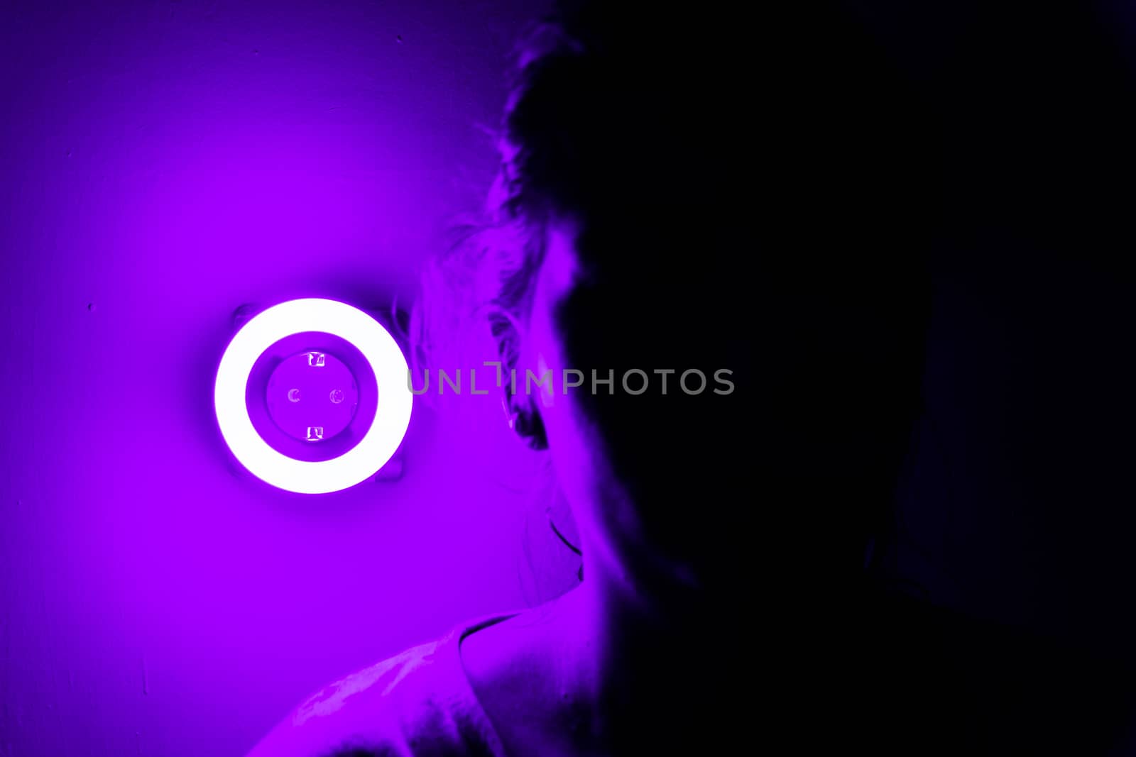 Lamp night light in a dark background. Vintage effect style picture. ring lamp. Neon light circle. the light takes the shape of a circle.the woman hiding in the dark. a symbol of violence for women