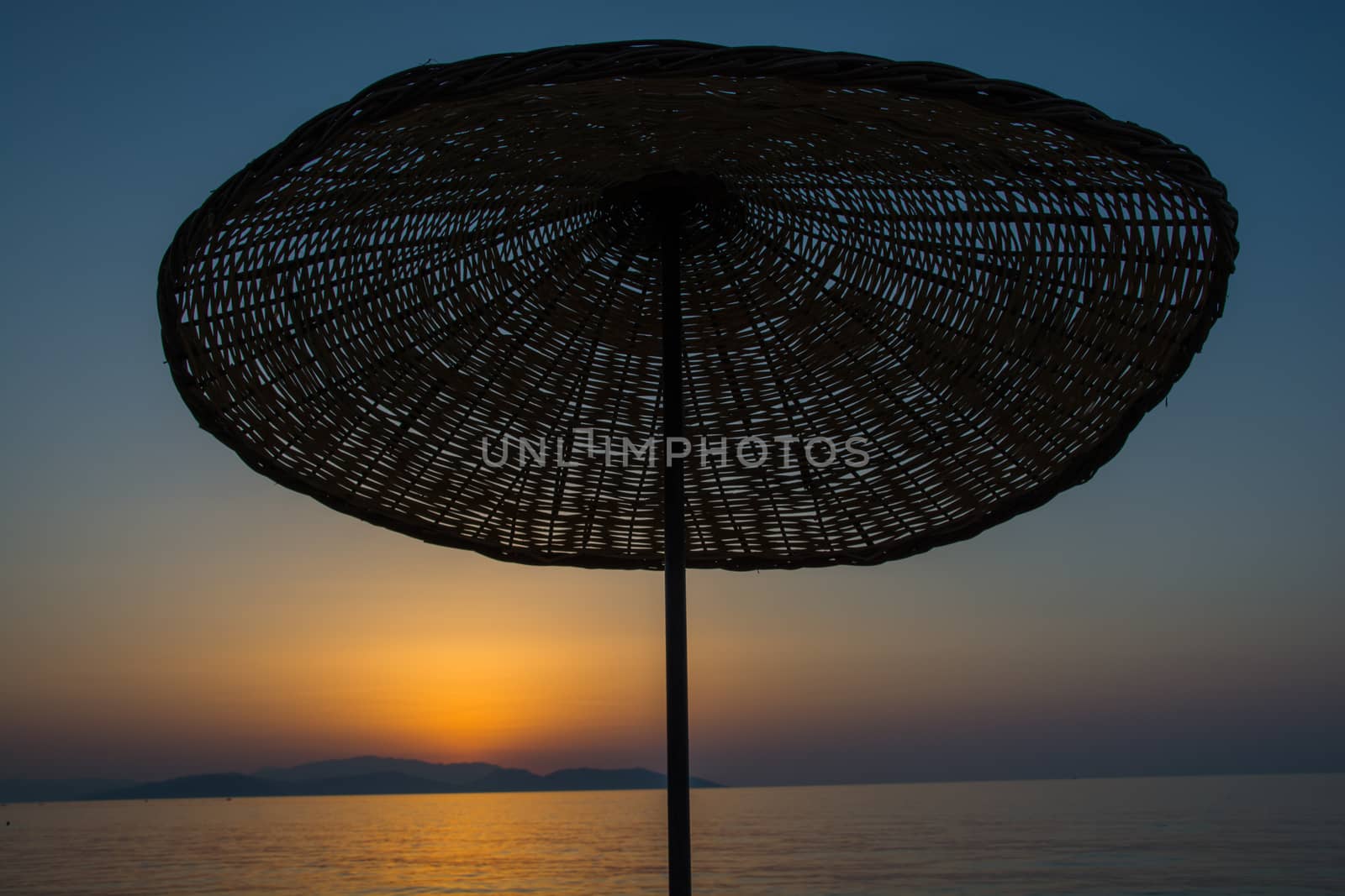 sunset. the umbrellas on the beach are empty and lonely.