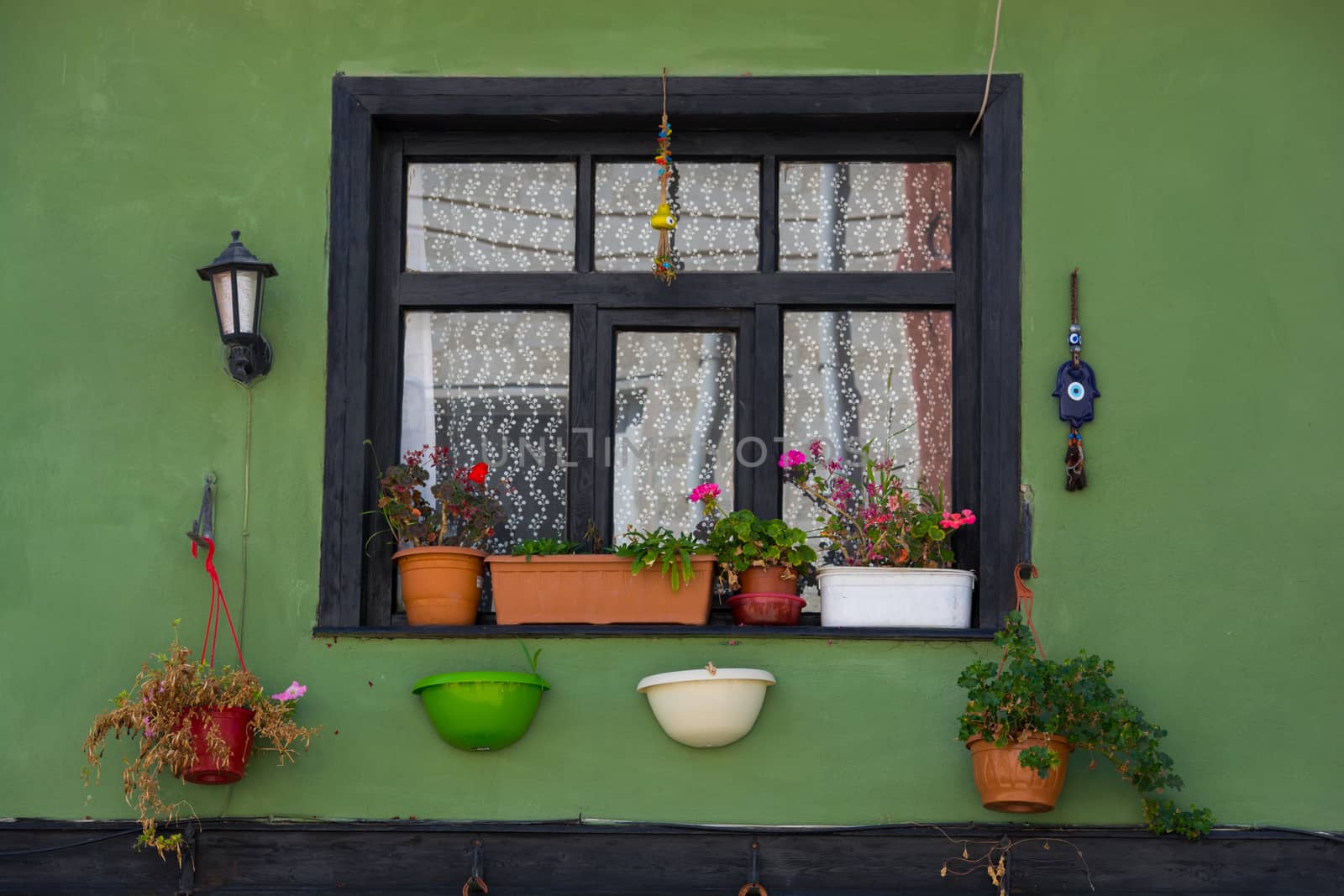 flowered window. house window decorated with flowers and beads