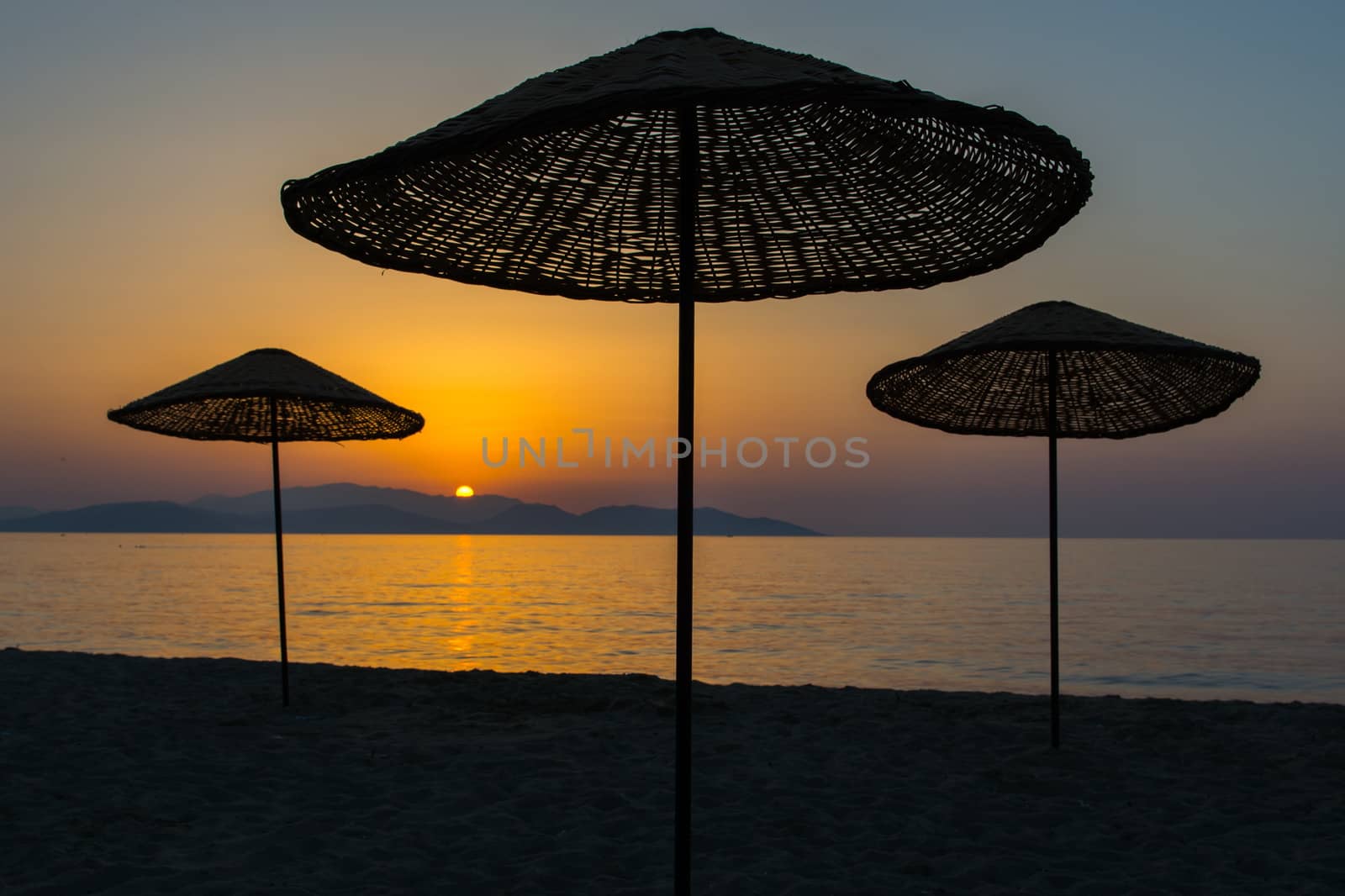 sunset. the umbrellas on the beach are empty and lonely.
