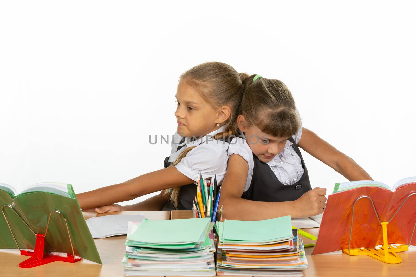 Two girls share a desk and push each other's backs