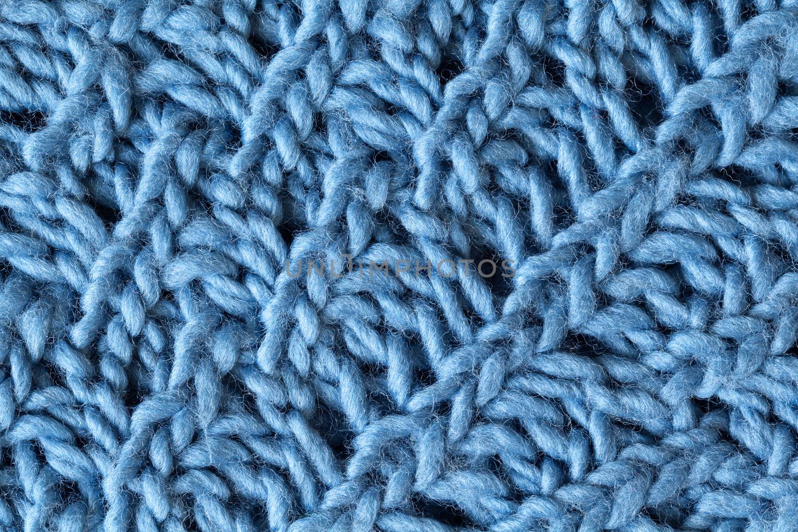 Knitted woolen textured surface, macro. Soft grey blue merino wool pattern backdrop, closeup. Autumn and winter flat lay. Scandinavian minimal style.