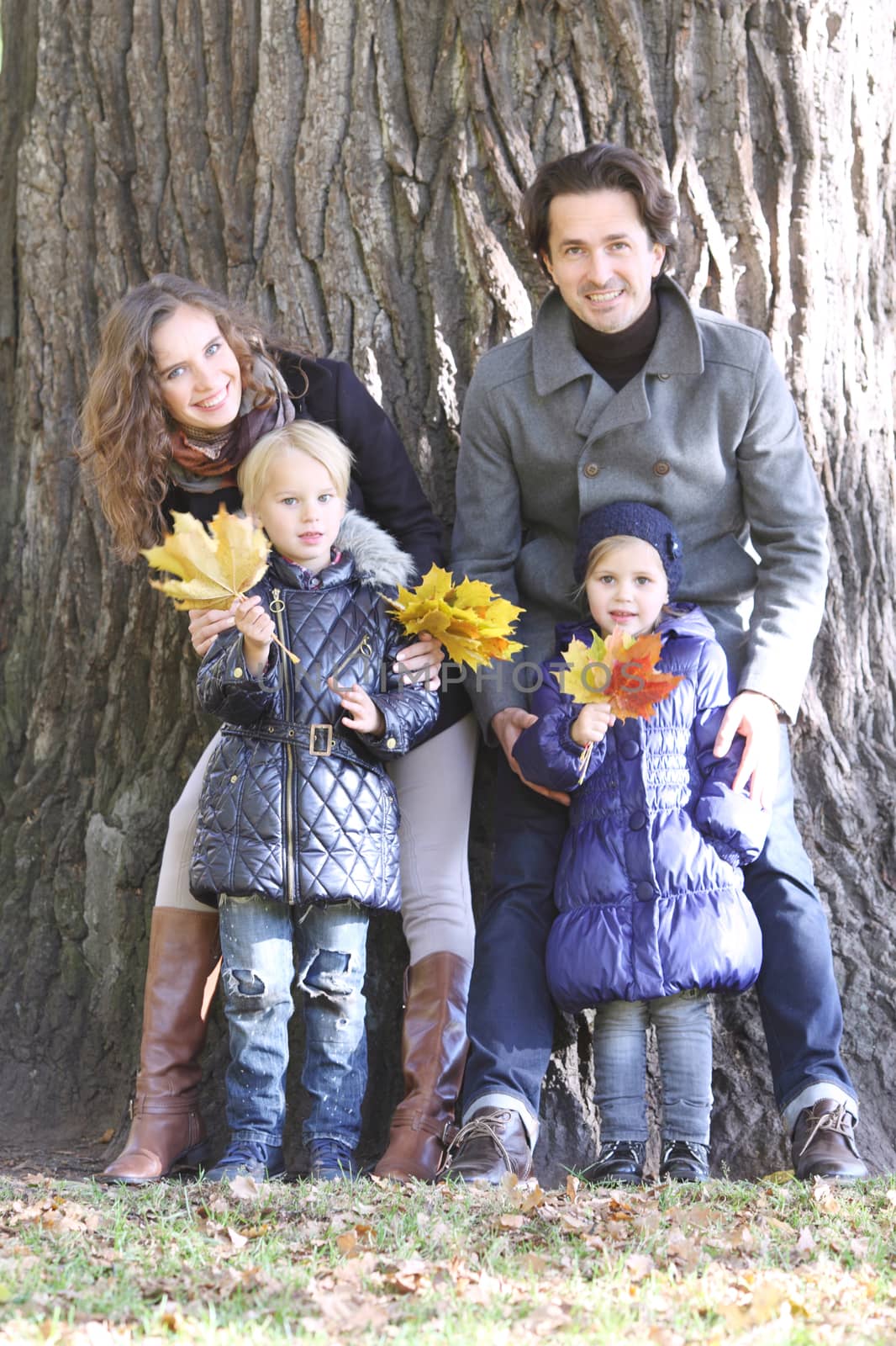 Happy smiling family of parents and children in autumn park