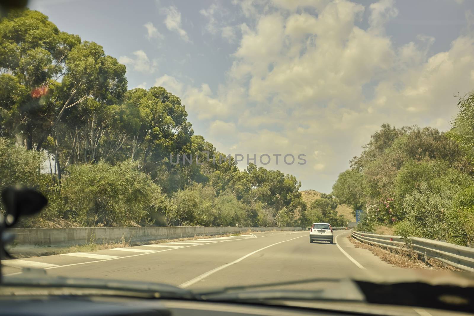 Drive on the road with a car in the street full of trees