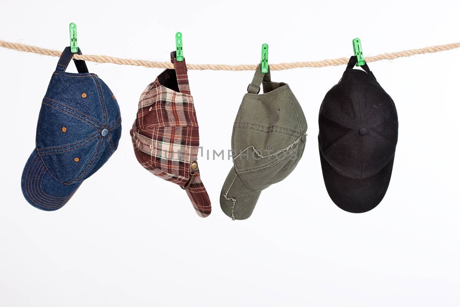 Different hats and caps hanging on a clothesline