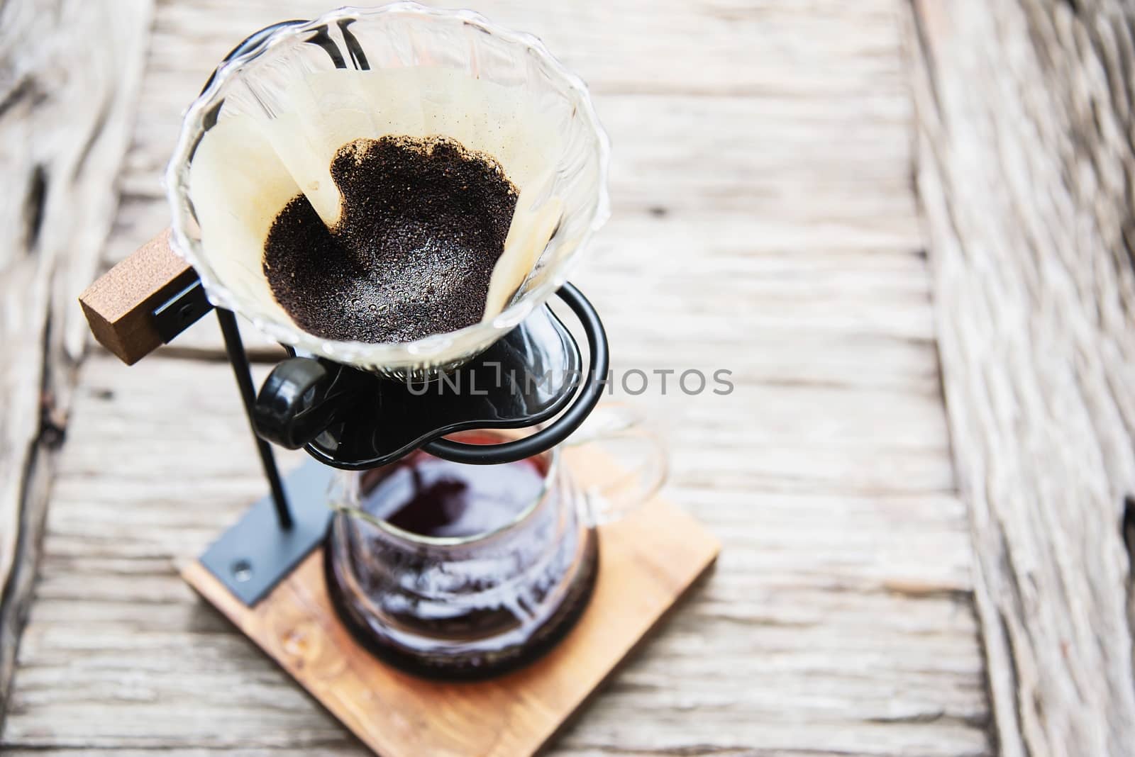 Man making drip fresh coffee in vintage coffee shop with green nature background by pairhandmade